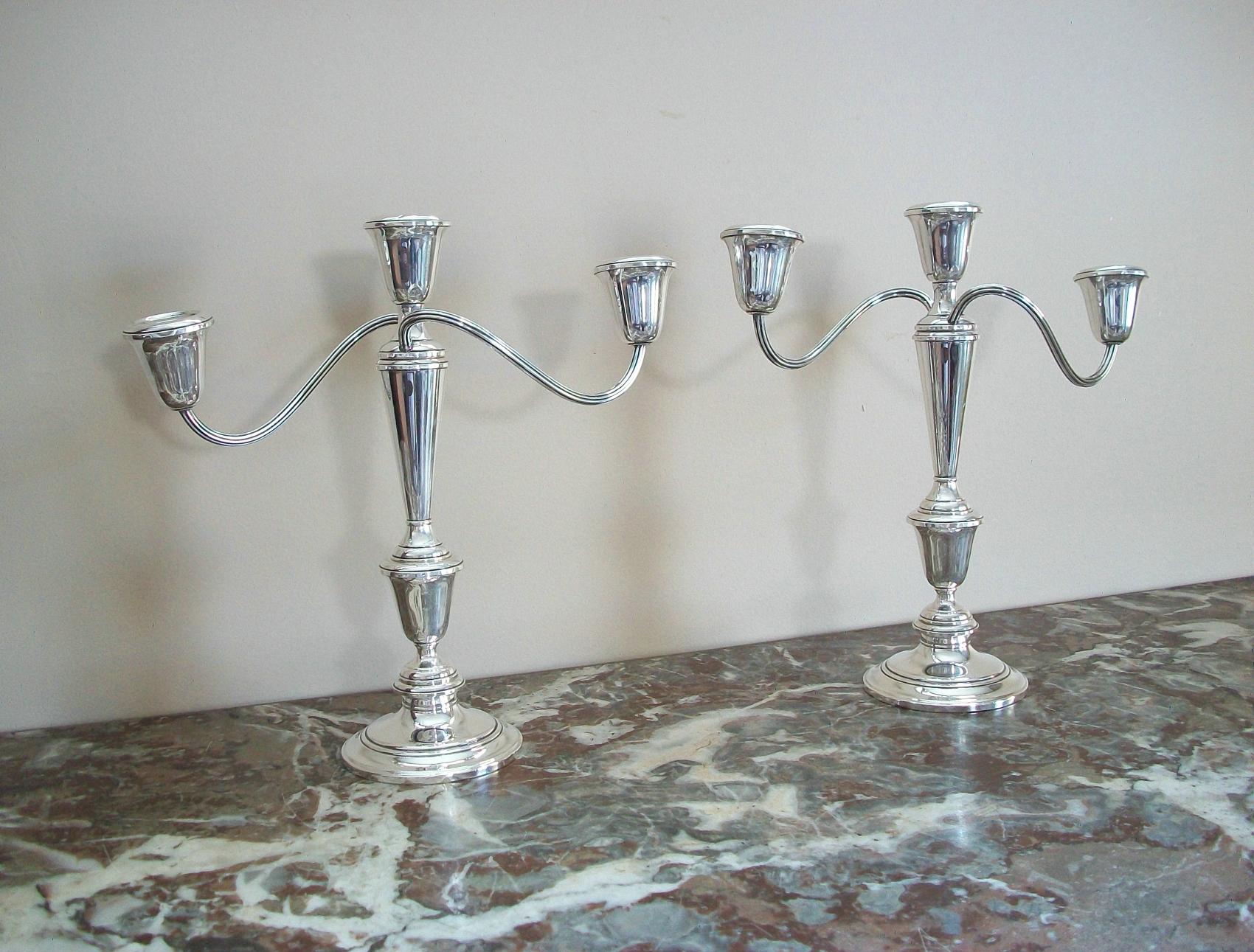 NEWPORT - Vintage pair of sterling silver candelabra - pattern number 16218 - weighted - classic traditional design - signed on the base - United States - mid 20th century.

Good vintage condition - one nozzle loose/wobbly but stable - few dents to
