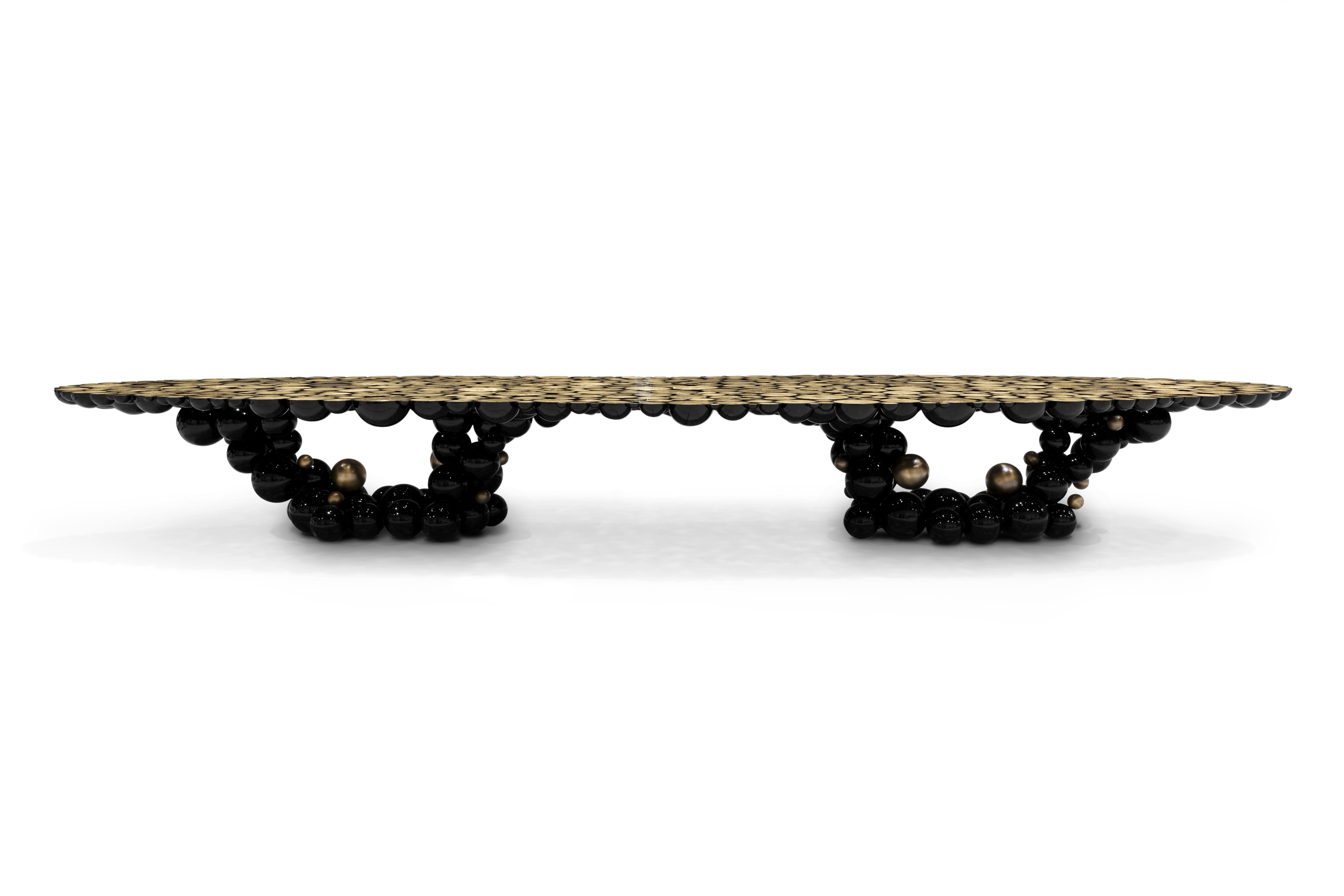 La table de salle à manger Newton défie les lois de la physique. Fabriquée selon l'art ancestral de la fonte des métaux, où le métal en fusion se transforme en sphères et demi-sphères, cette table transcende l'ordinaire. Chef-d'œuvre contemporain