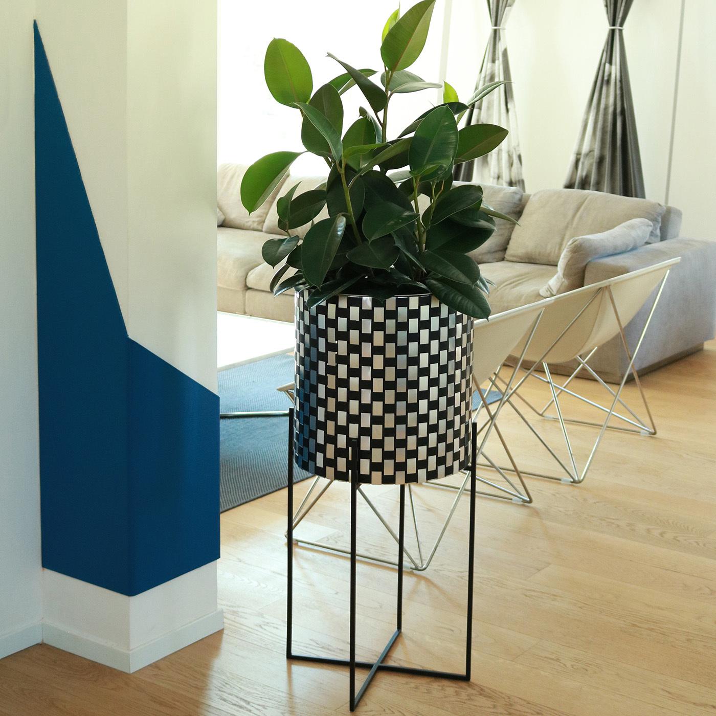 This sublime plant holder was designed to stand out in any decor. The black-painted iron structure (H 60cm) supports a cylindrical steel pot fashioned using a unique material patented by Inthegarden Design Studio featuring woven sheets of black- and