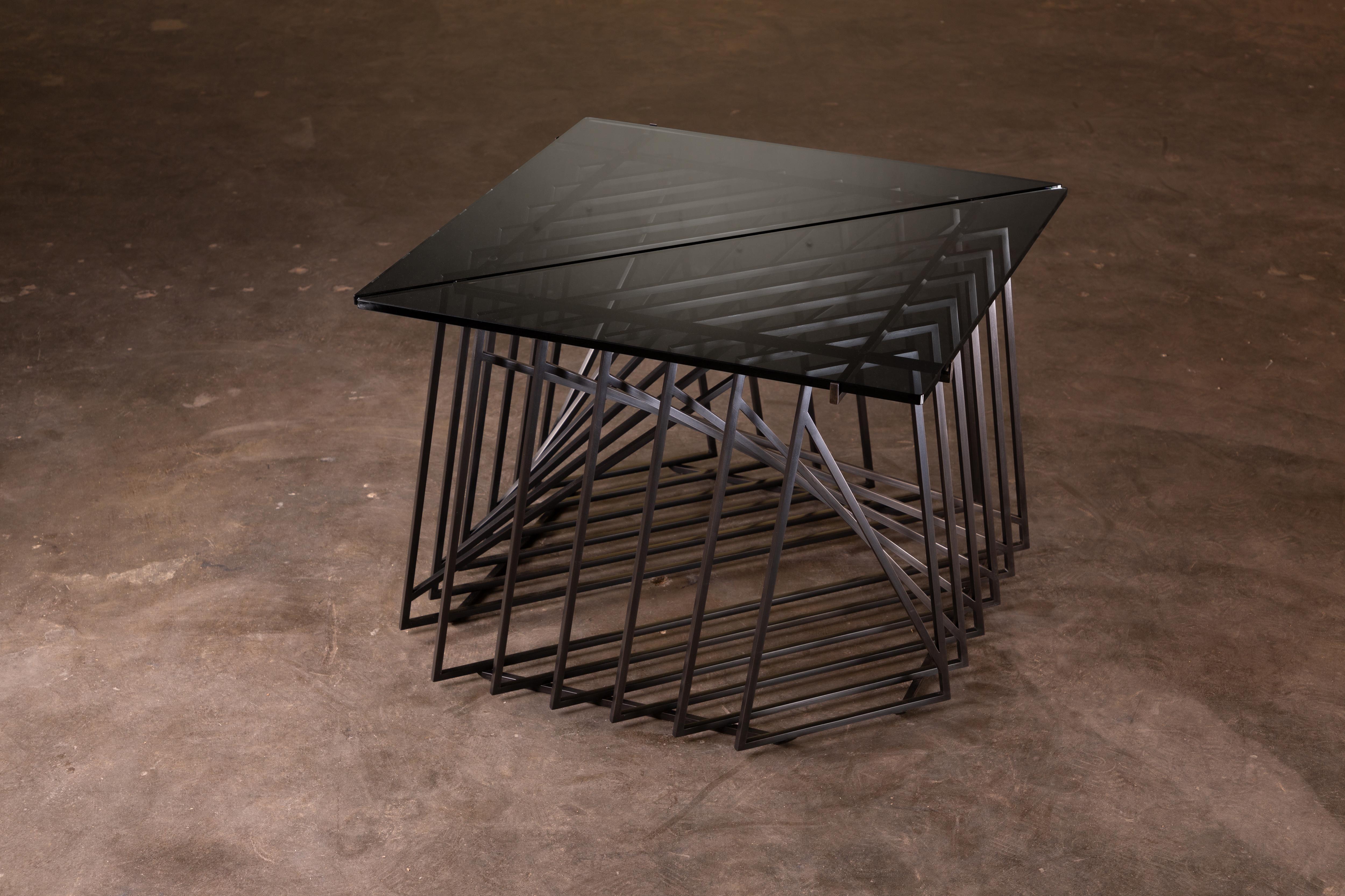Die Nexus Beistelltische sind eine skulpturale Studie, fein konstruiert und mit satiniertem schwarzem Oxidstahl und rauchgrauem Glas verarbeitet. Die vielseitigen und modularen dreieckigen Tische können ganz individuell gestaltet werden, so dass sie