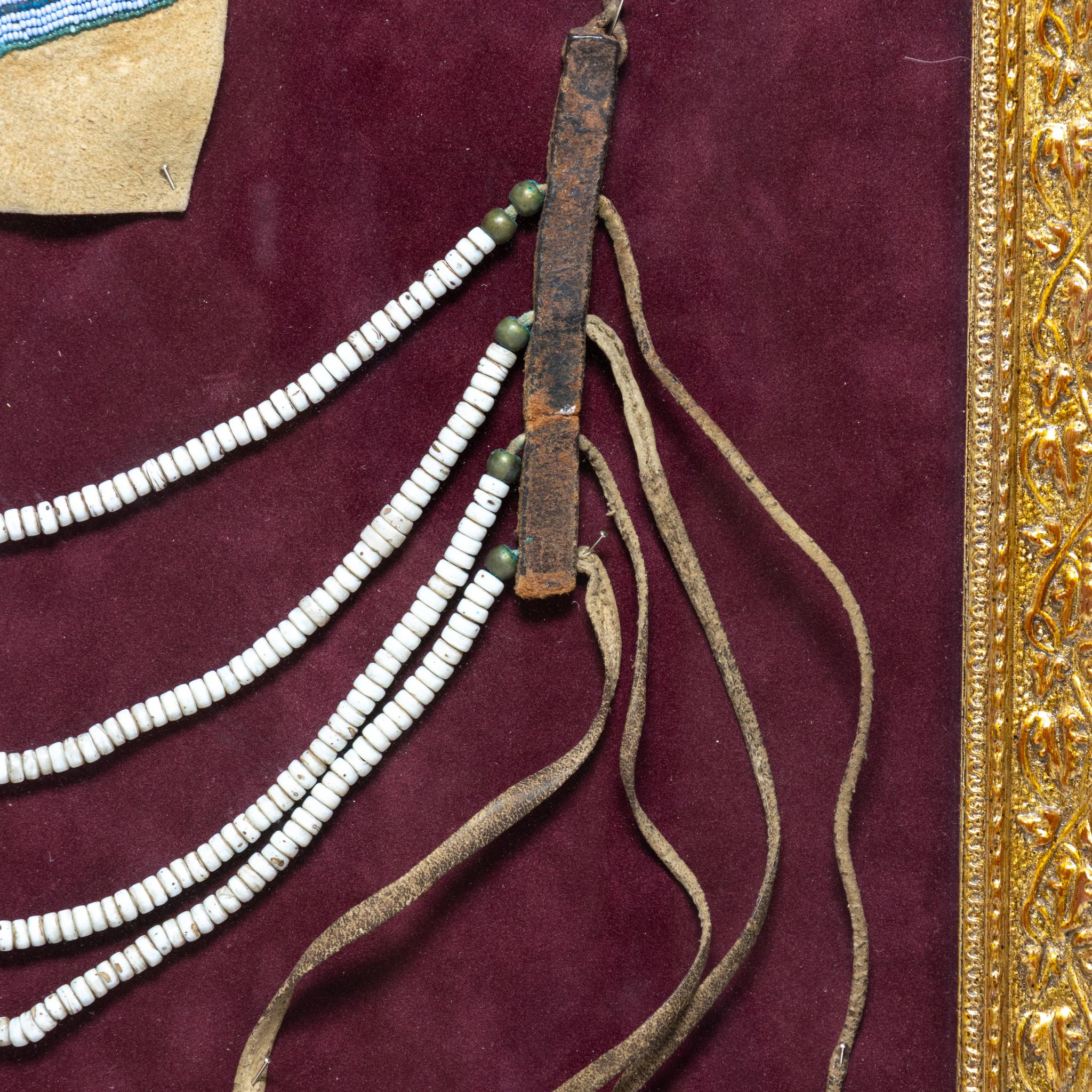 Pair of 19th Century man's loop necklace and finely beaded gauntlet panel. Necklace has white and green beads and leather fringe, base, and twisted cord tie. Gauntlet features floral design with colors of blue, green, yellow, and orange. Shadow box