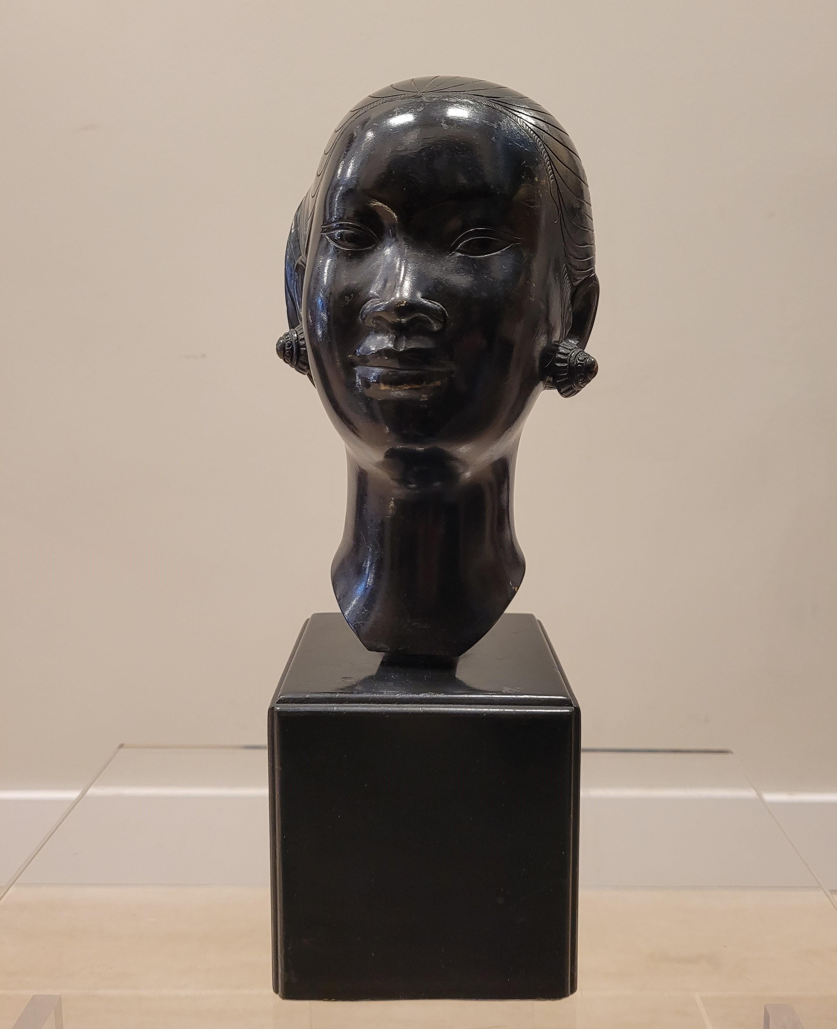 Gorgeous and evocative bust of a young Vietnamese (or Laotian, depending on the source) woman with her hair up. Made in Vietnam around 1950 by renowned artist Nguyen Thanh Le. Made of bronze with ebonized finish and wooden base. A naturalistic