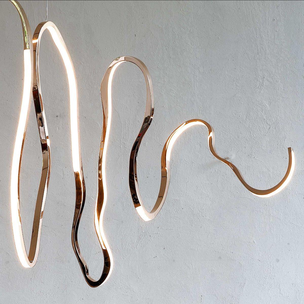 Avec la main de l'artiste, Niamh Barry montre une fois de plus sa maîtrise dans la transmission de belles formes de mouvement avec du bronze poli et des diodes électroluminescentes. Dans ce cas, l'artiste irlandaise, en utilisant des éléments