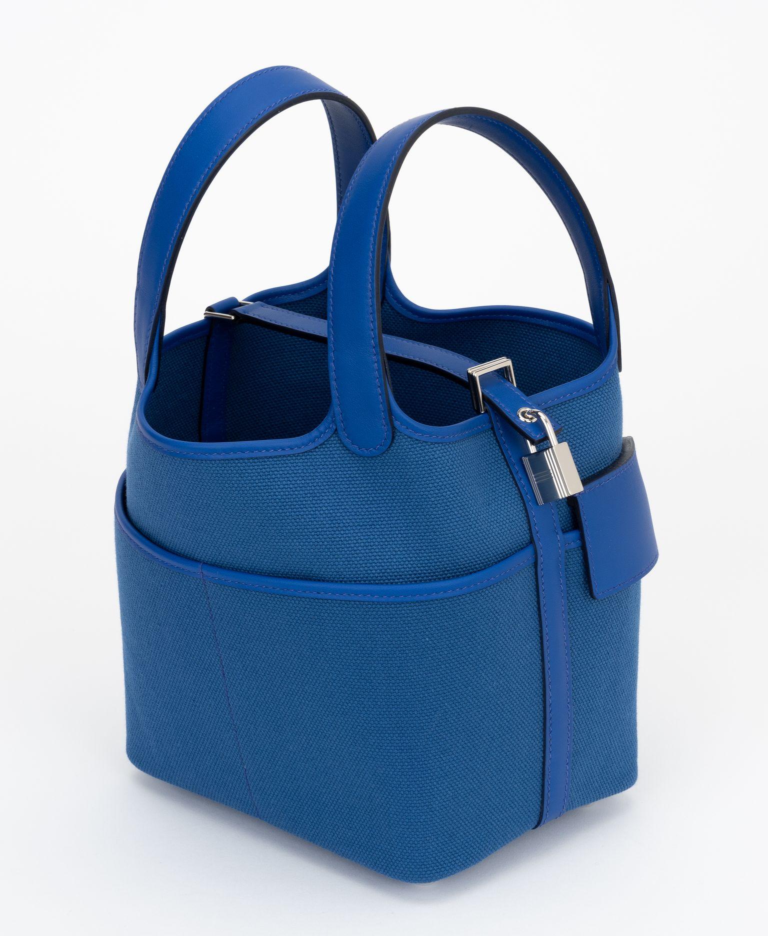 Hermès new in box blue royal Swift and Toile Geoland Cargo Picotin Lock 18, palladium hardware . This chic and lovely tote is crafted of sturdy canvas in blue royal. The bag features looping leather top handles, exterior pockets, and palladium