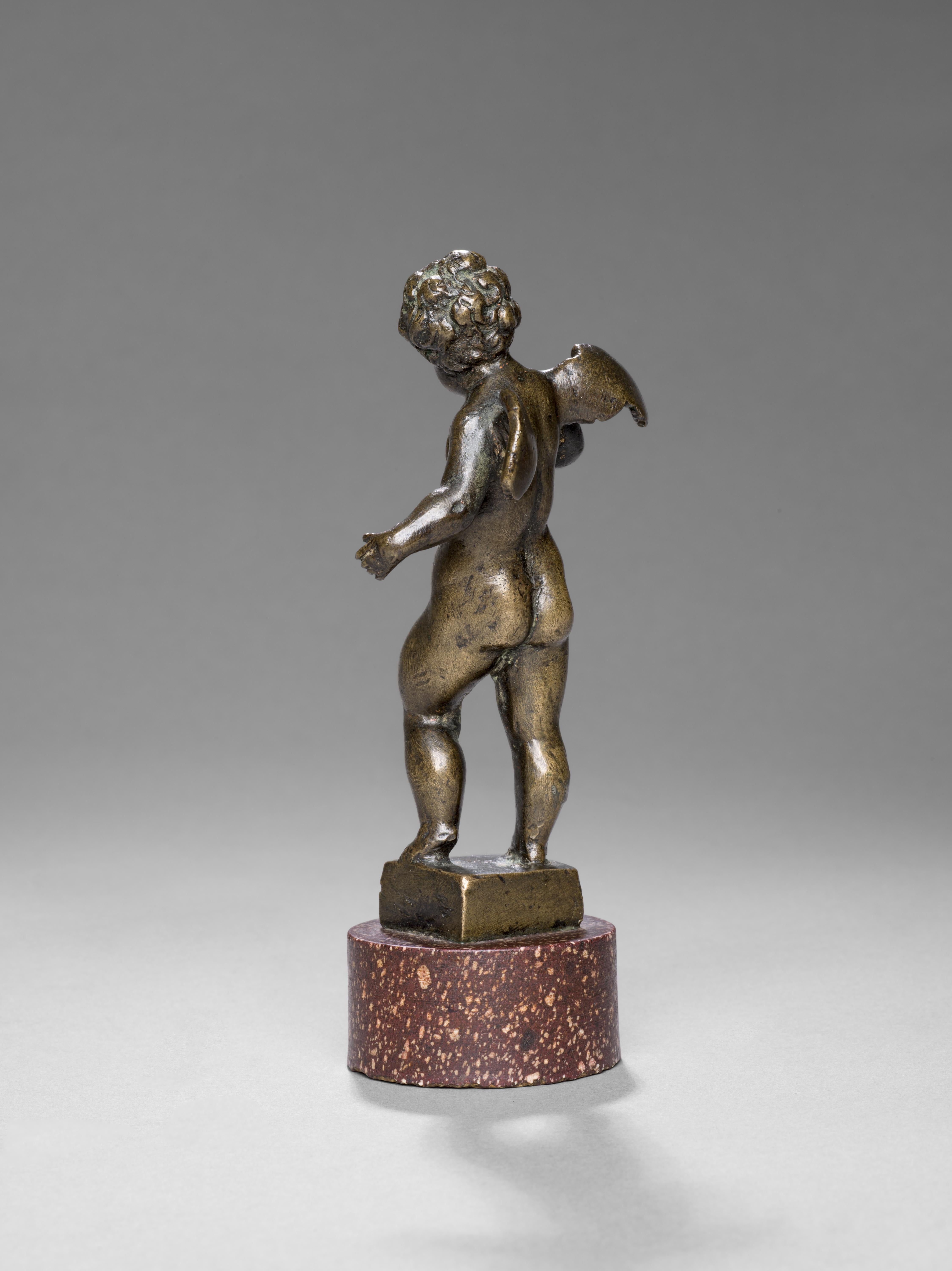Reposant sur une base circulaire en porphyre égyptien, cette fascinante figure en bronze d'un jeune chérubin est un exemple frappant de l'art vénitien du XVIe siècle. La tête légèrement tournée vers la droite et la main droite posée sur la poitrine,