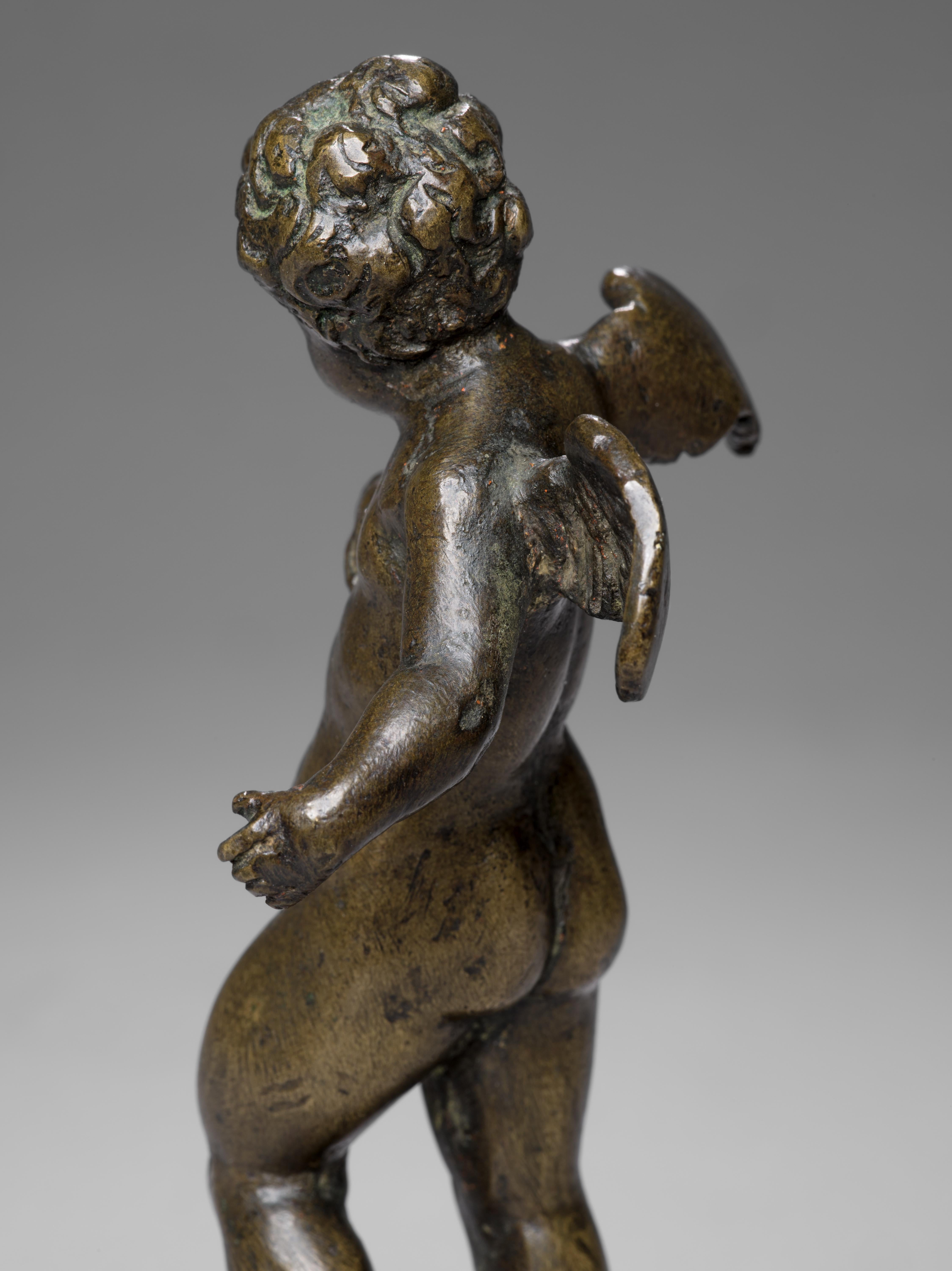 Resting on a circular Egyptian porphyry base, this fascinating bronze figure of a young cherub is a striking example of the Venetian workmanship of the 16th Century. With the head turned slightly to the right and the right hand resting on the chest,