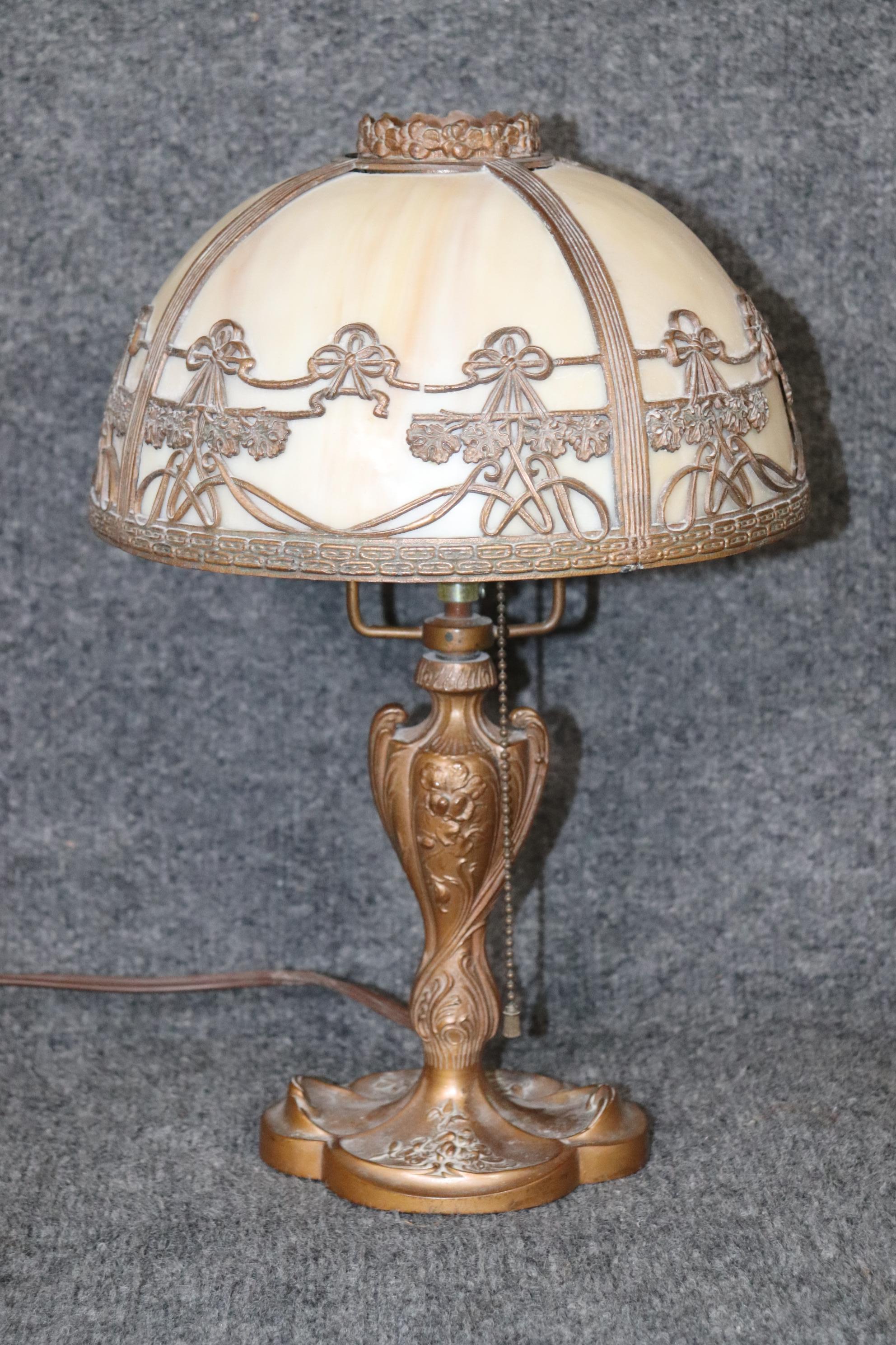 This is a beautiful bronze colored spelter base slag glass lamp in the art nouveau style in good condition. The wiring may need to be redone as it is antique.