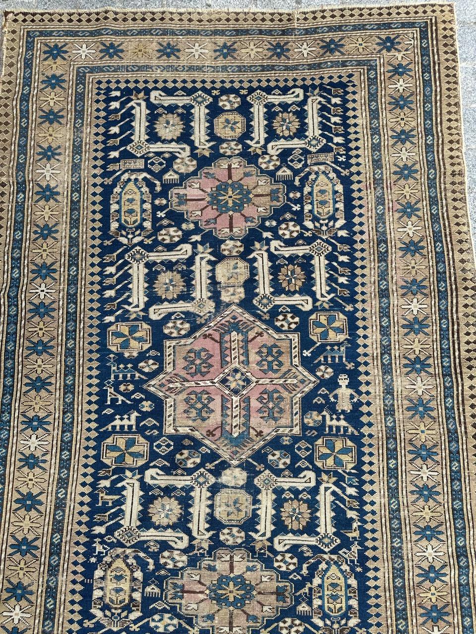Grazioso tappeto shirvan caucasico della fine del XIX secolo con bellissimi disegni geometrici e stilizzati e bei colori naturali con campo blu, rosa, blu, giallo marrone e grigio nel disegno, interamente annodato a mano con lana su base di lana.