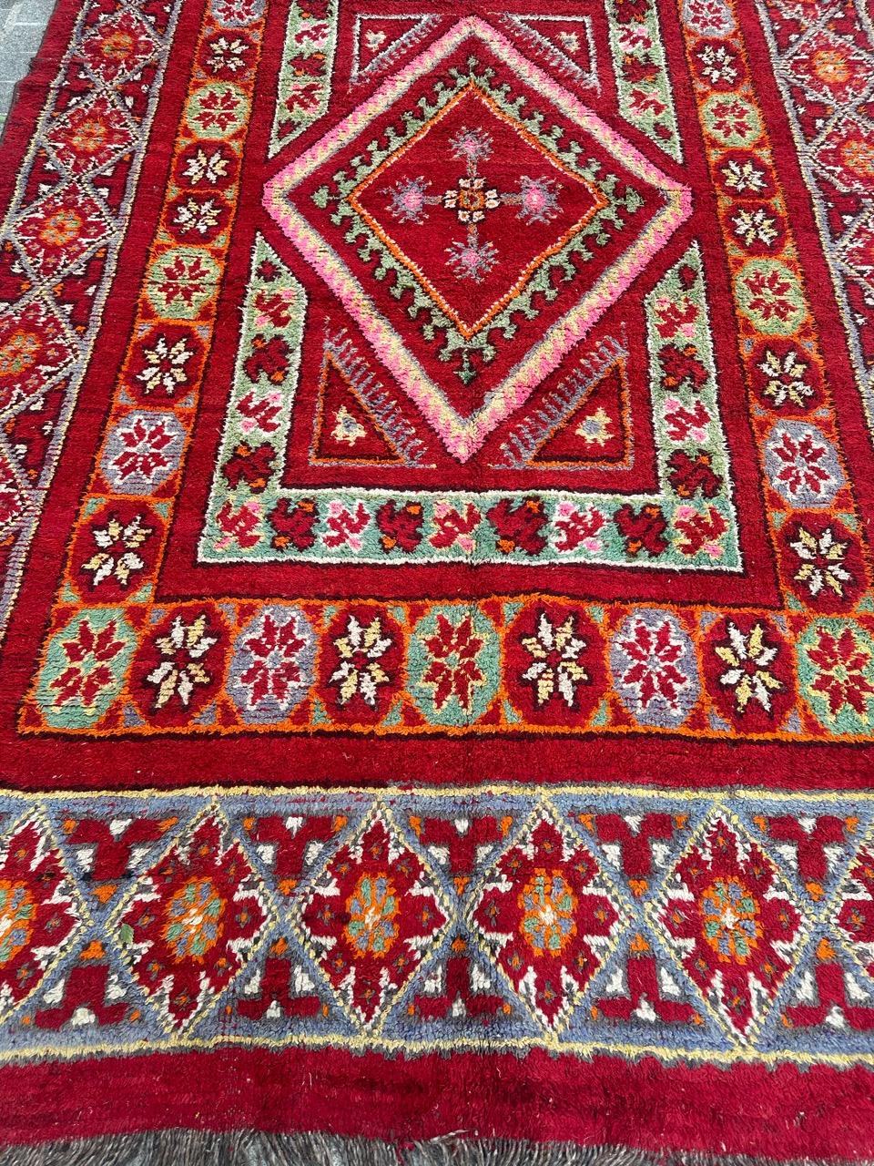 Colourful late 19th century tribal Moroccan rug  with nice geometrical and stylized designs and beautiful natural colours with a red background green, orange, pink, green, orange, purple and white, entirely hand knotted with wool on wool