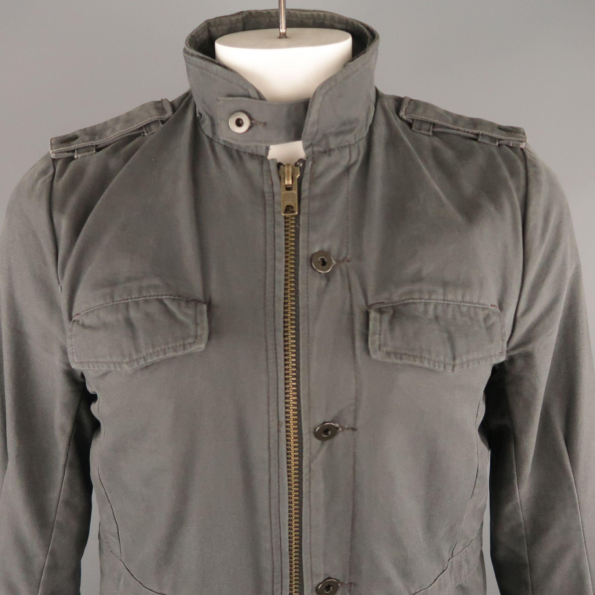 NICE COLLECTIVE  Military Style Jacket comes in a dark grey tone in a solid cotton material, with a double high collar, epaulettes, flap and slit pockets, zip and buttons. Made in USA.
 
Very Good Pre-Owned Condition.
Marked: L
 
Measurements:
