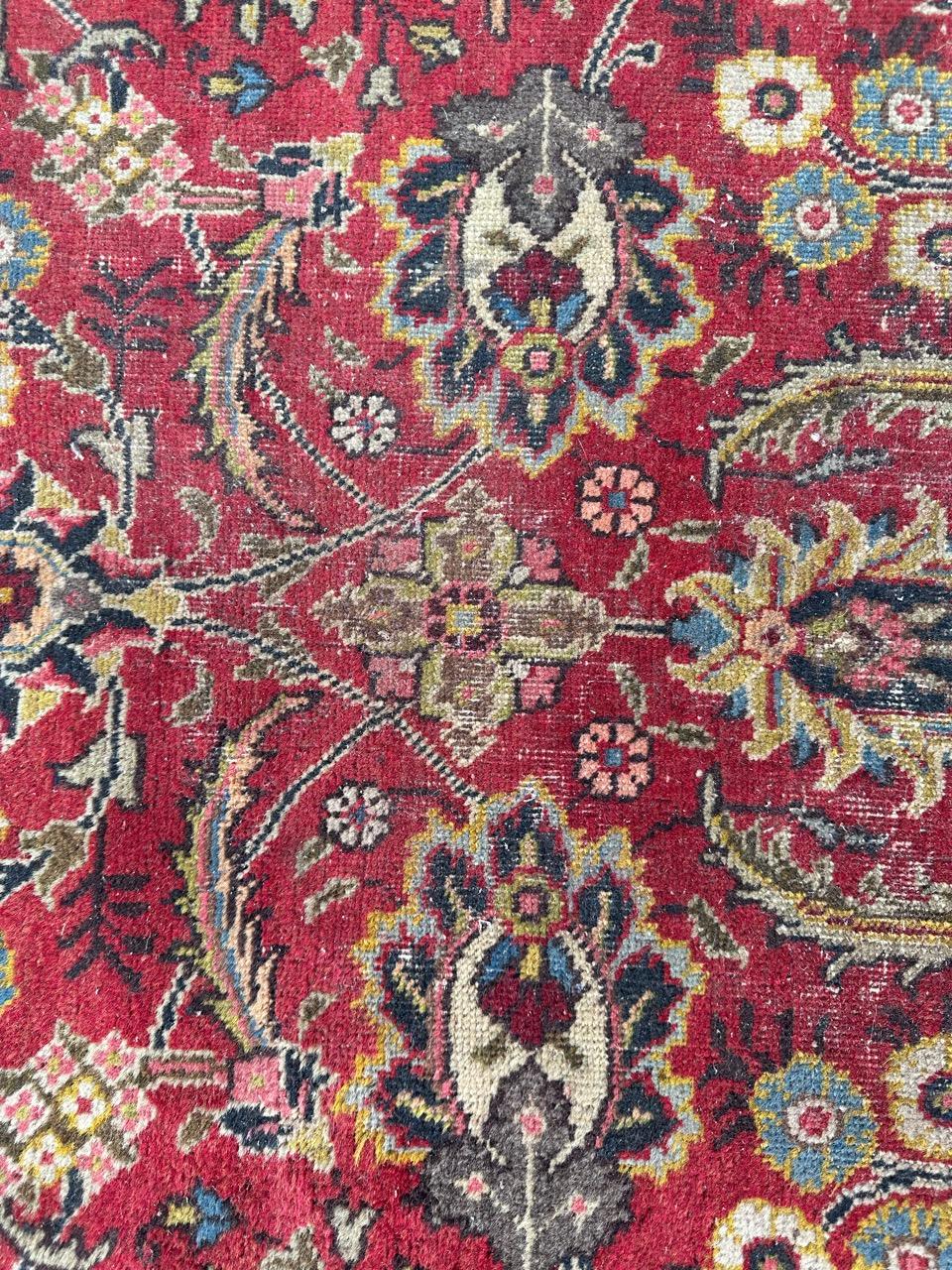 Pretty antique tabriz rug entirely hand knotted with wool velvet on cotton foundation.
A vintage rug dating back to the first half of the 20th century, rich in history and character. Enveloped in a vibrant red backdrop, this rug showcases elegant