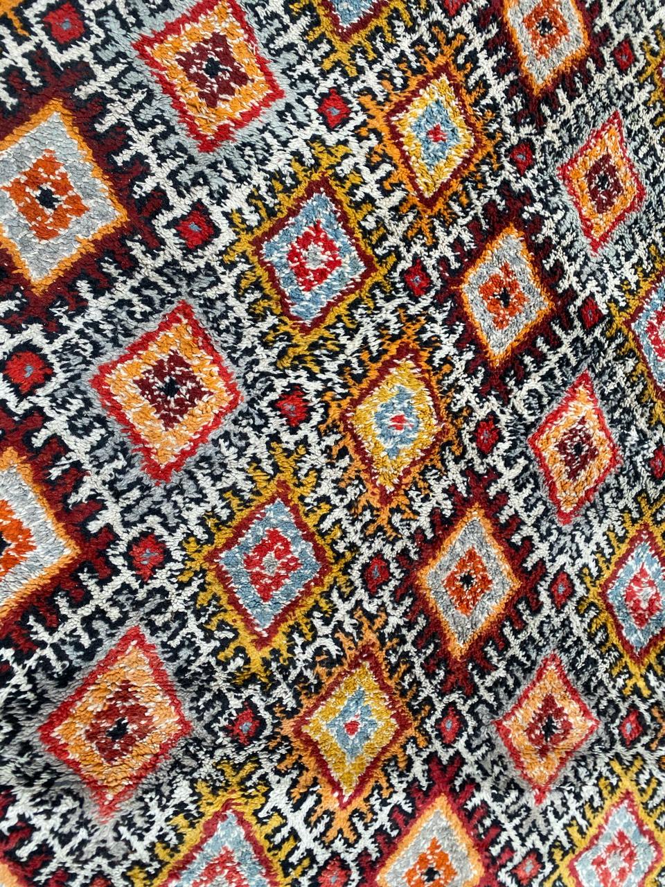 Preciosa alfombra marroquí con un bonito diseño geométrico y hermosos colores naranja, rojo, azul y morado, anudada totalmente a mano con terciopelo de lana sobre base de algodón. Tamaño: 5,83 x 7,74 pies.