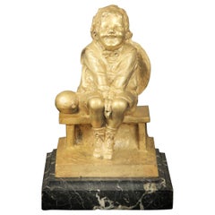 Bella scultura in bronzo dorato di un bambino seduto su una base di marmo di Juan Clara
