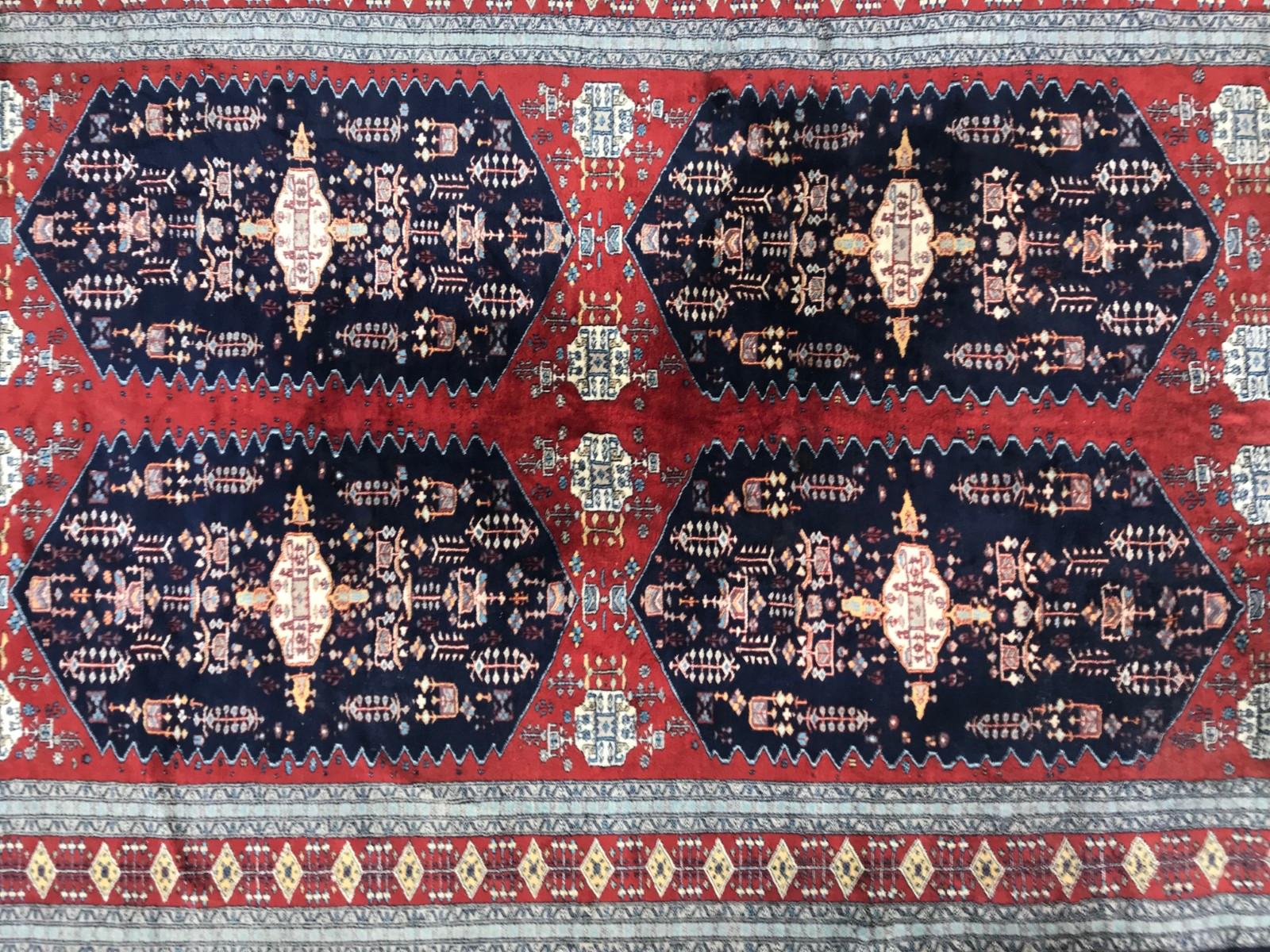 Beautiful fine Pakistani rug, late 20th century, with a geometrical design and nice colors, with red and blue field, entirely and finely hand knotted with wool velvet on cotton foundations.