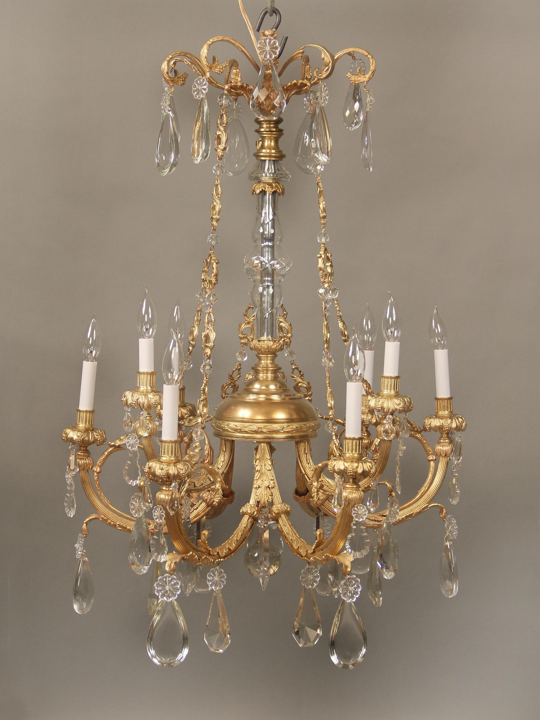 A nice late 19th century gilt bronze and crystal nine light chandelier

Multifaceted and shaped crystal including half pear designs, cut crystal central column, sculpted bronze chains connecting the crown and body, nine perimeter lights.