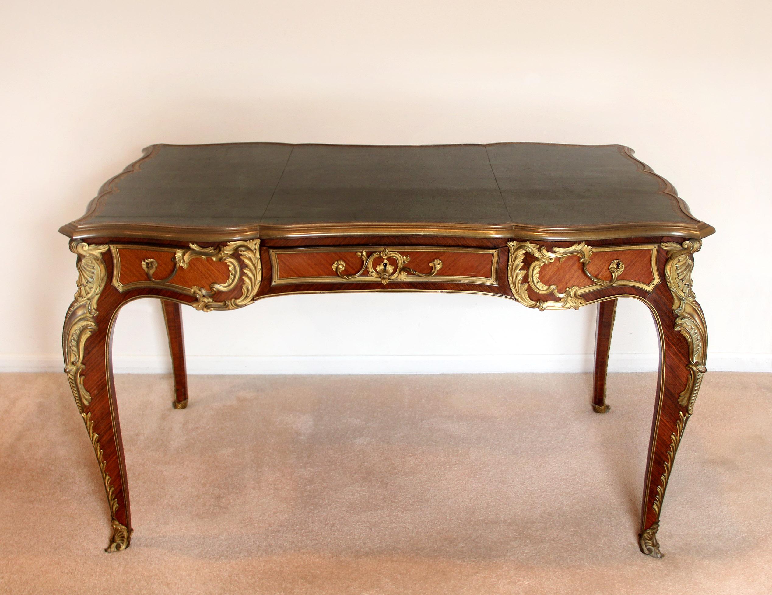 A Nice Late 19th Century Louis XV Style Gilt Bronze Mounted Bureau Plat


The rectangular top with gilt-tooled leather writing-surface within a molded border, above a quarter-veneered serpentine frieze, three drawers to the front and three simulated