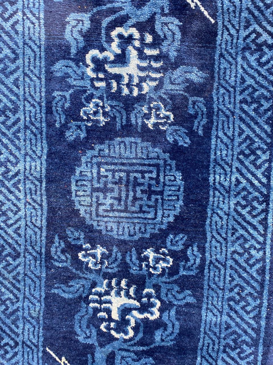 Exquis tapis chinois de la fin du XIXe siècle présentant un étonnant design chinois, orné d'un captivant champ de couleur bleue. Méticuleusement noué à la main avec du velours de laine sur une base de coton. Ne manquez pas la chance de posséder