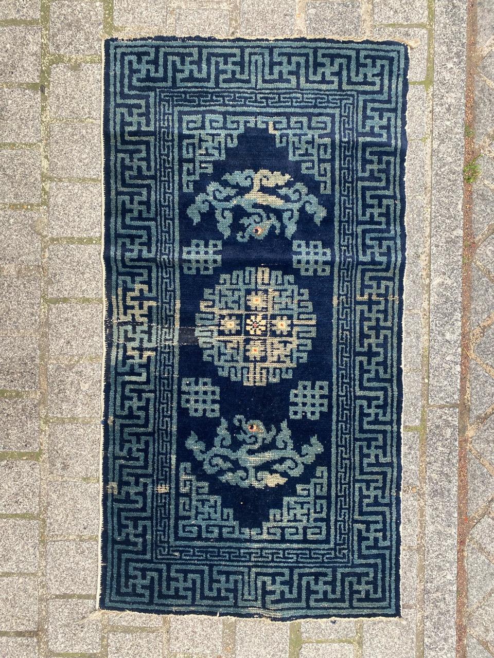 Exquisite small Chinese rug from late 19th century Beijing. Hand-knotted with wool on cotton, this rug features a stunning Chinese design. A decorative medallion with sky-blue lines and stylized flowers is set against a deep midnight blue