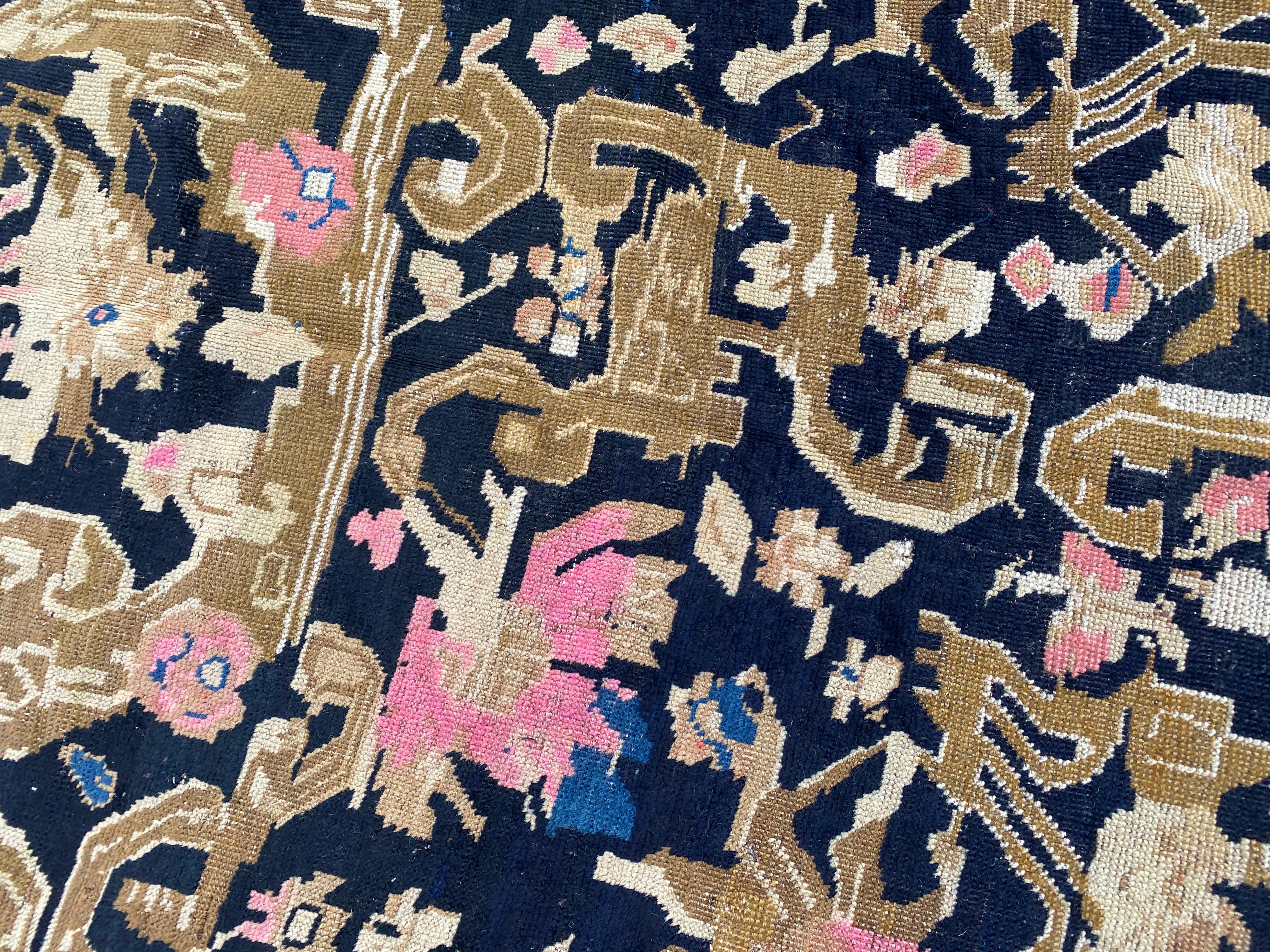 Discover the timeless elegance of a charming early 20th-century Karabagh rug. Immerse yourself in its exquisite decorative design and vibrant colors – from the rich dark brown backdrop adorned with stylized pink flowers and golden arabesques to the