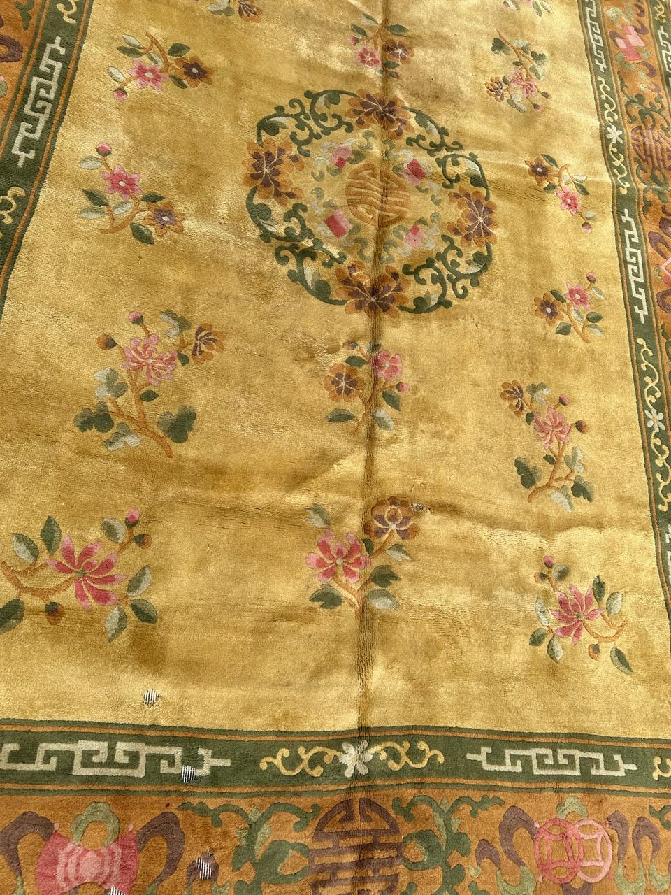 Preciosa alfombra china de mediados de siglo con un hermoso diseño art déco chino en fondo amarillo con un hermoso medallón floral y algunas flores a su alrededor en rosa, rojo, dorado y verde, y un ribete muy hermoso sobre fondo dorado adornado con