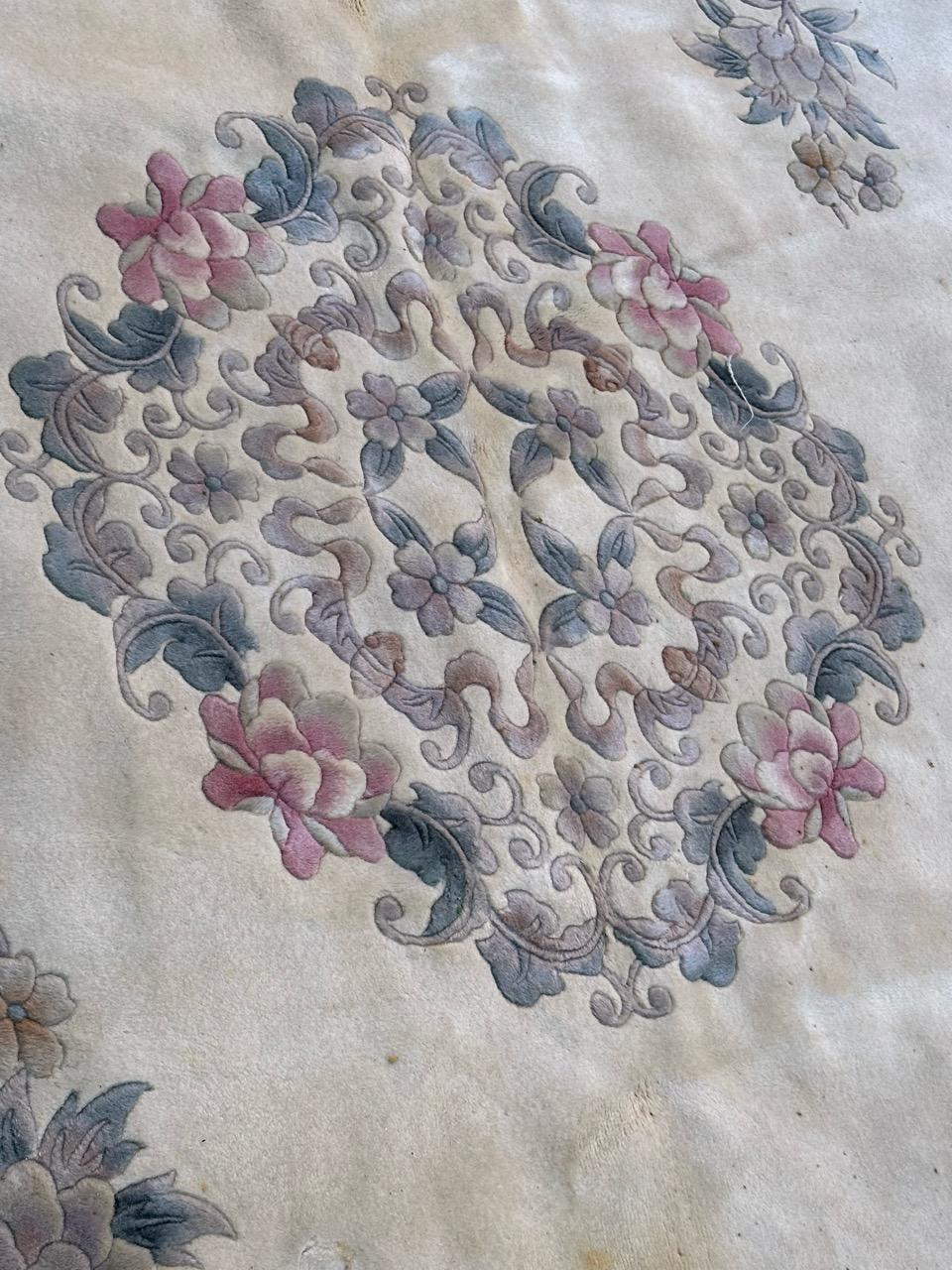 Very beautiful mid century Chinese rug with beautiful Chinese art deco design in a white background with a beautiful floral medallion and some flowers around it in pink, green, yellow, blue and purple , and a beautiful border on a red background