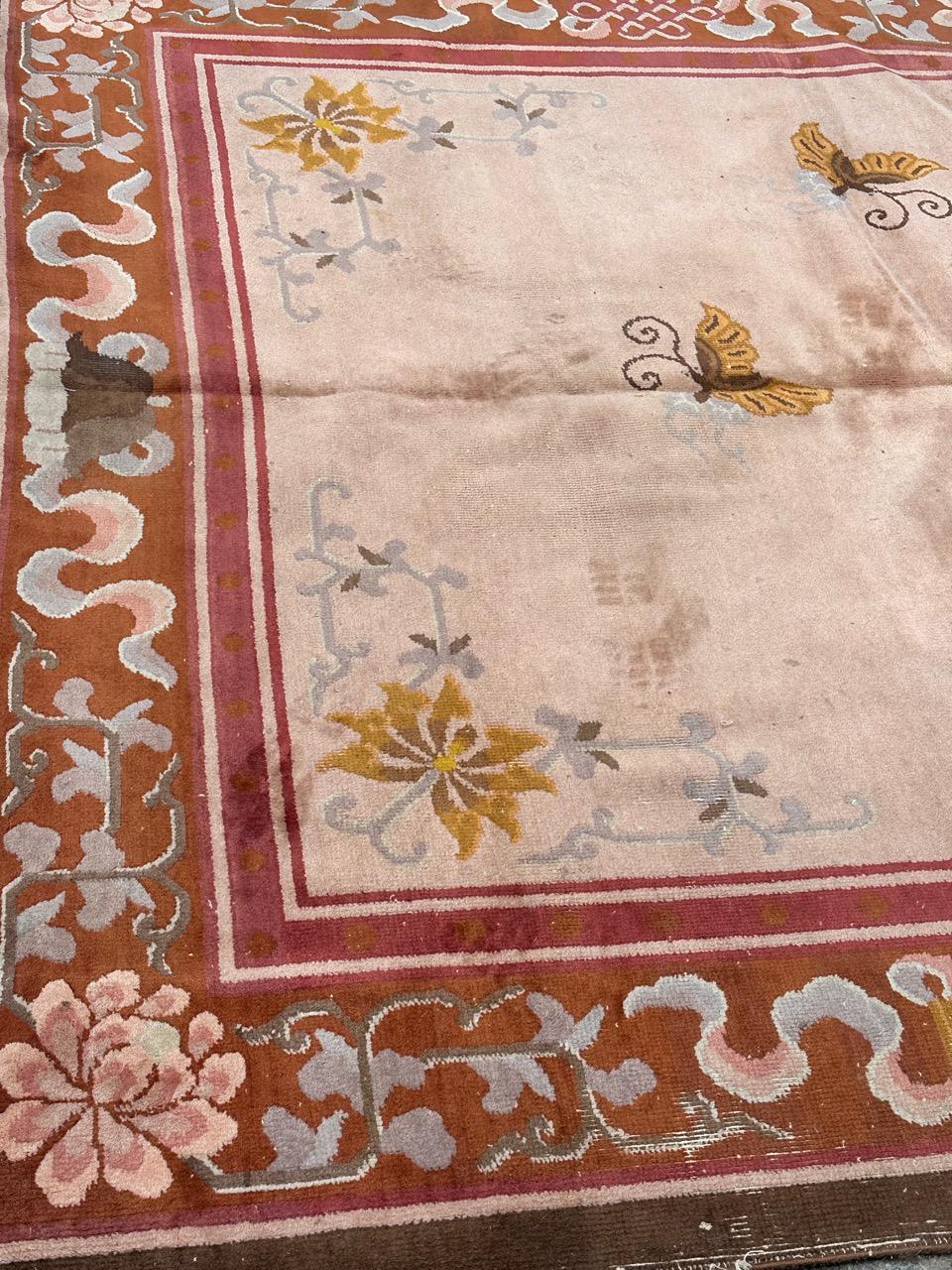 Very beautiful mid century Chinese rug with beautiful Chinese art deco design in a pink background with a beautiful central medallion and some butterflies around it in yellow, brown and light blue, and a beautiful border on a red background and