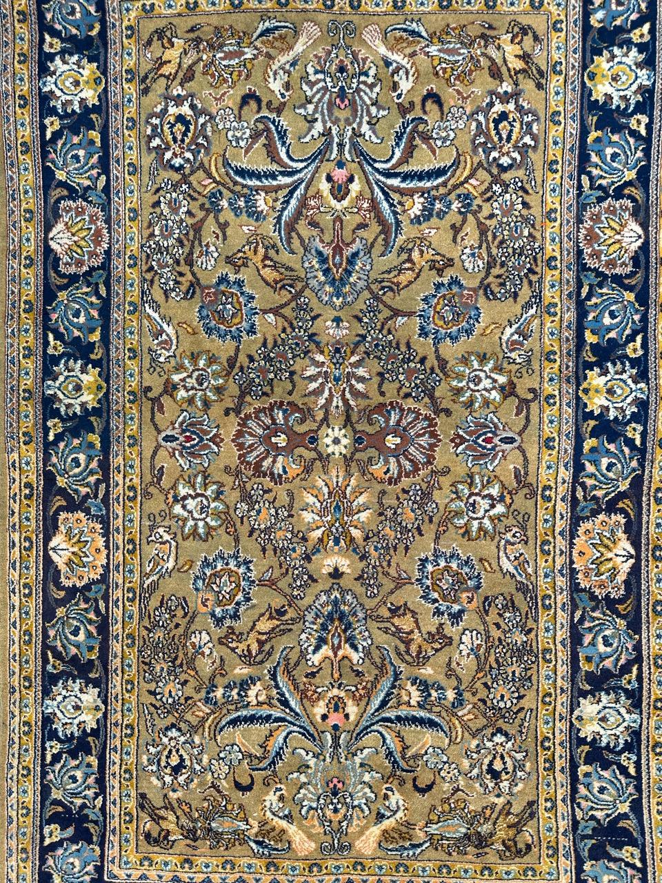 A mid 20th-century masterpiece – a Kashan rug, meticulously handwoven with a blend of wool and delicate silk accents on a sturdy cotton foundation. This elegant piece boasts stylized floral motifs and a rich natural color palette. The mustard yellow