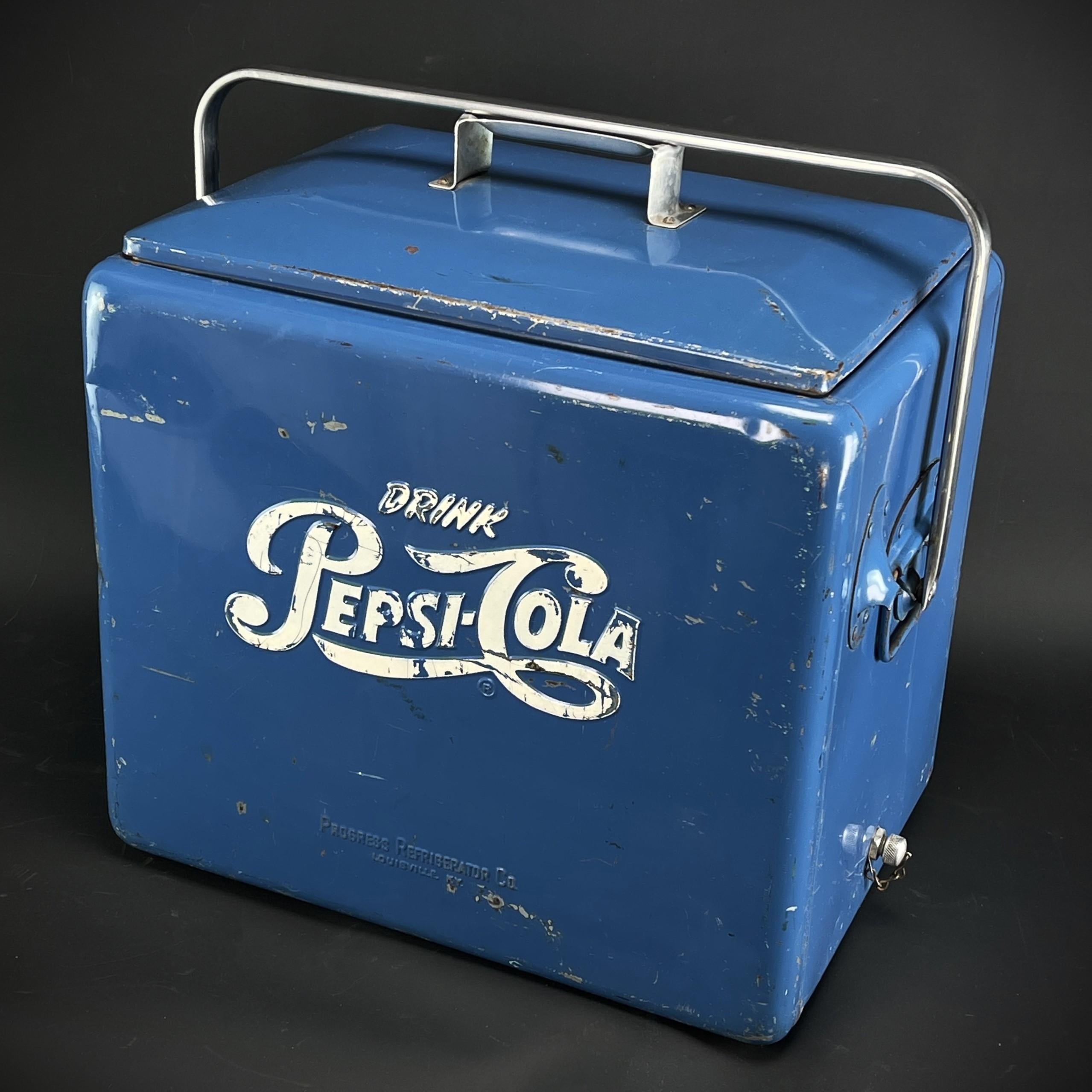 Nevera Pepsi Cola de mediados de siglo caja de bebidas nevera de hielo azul, años 50

La nevera/caja de bebidas decorativa de Pepsi Cola conserva la pintura original con la impresión publicitaria blanca de Pepsi Cola 