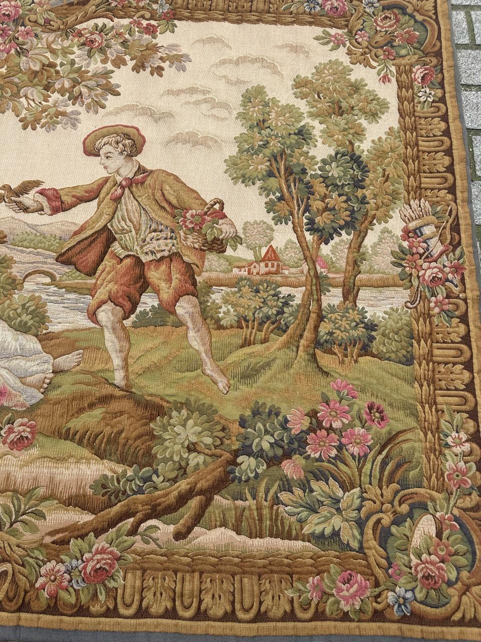 Außergewöhnlicher französischer Wandteppich aus der Mitte des 20. Jahrhunderts, gewebt auf Jacquard-Webstühlen im Halluin-Stich mit Wolle und Baumwolle. Es wurde von François Boucher inspiriert und zeigt einen Herrn, der zwei Damen vor einer