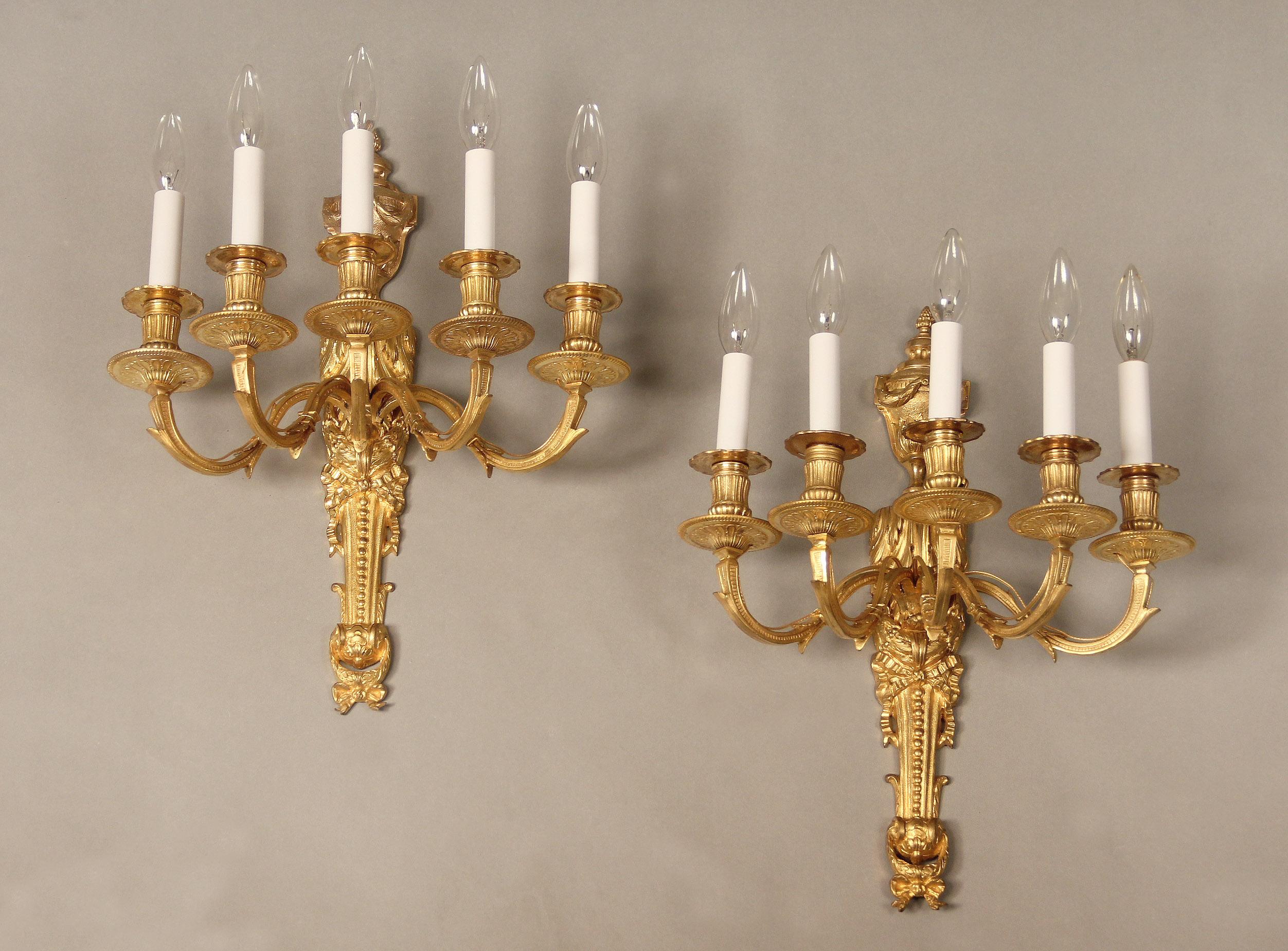 A nice pair of early 20th century gilt bronze five-light sconces

The top centered with an urn and the body with a tied bow, five scrolled arms.