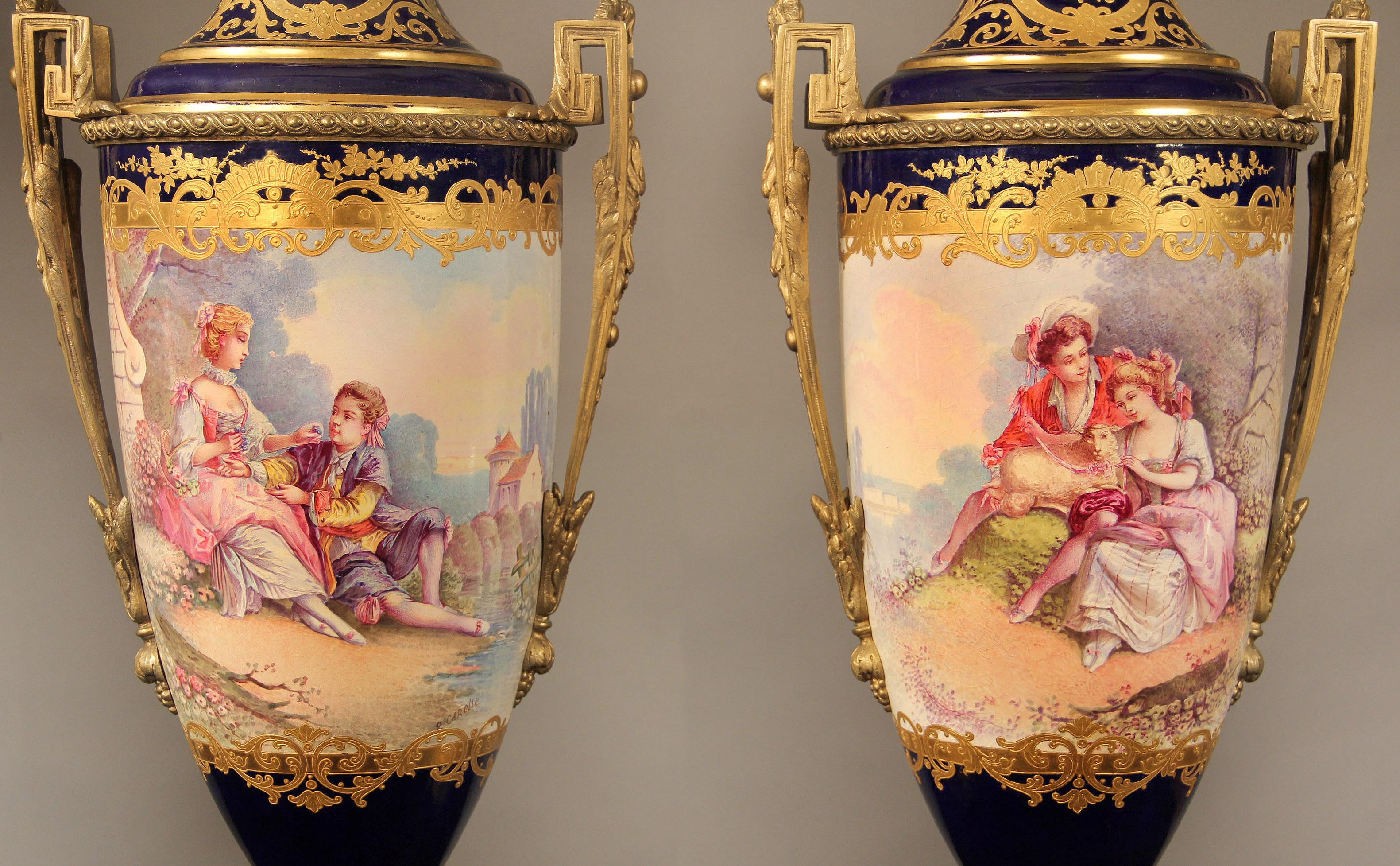 A nice pair of late 19th century gilt bronze mounted cobalt blue Sèvres style porcelain vases

The vases are decorated with finely tooled gilt reserves on a deep blue ground; the wraparound painted scenes with courting couples inspired by the fete