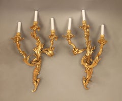 Bonito par de candelabros de tres luces de bronce dorado estilo Luis XV de finales del siglo XIX