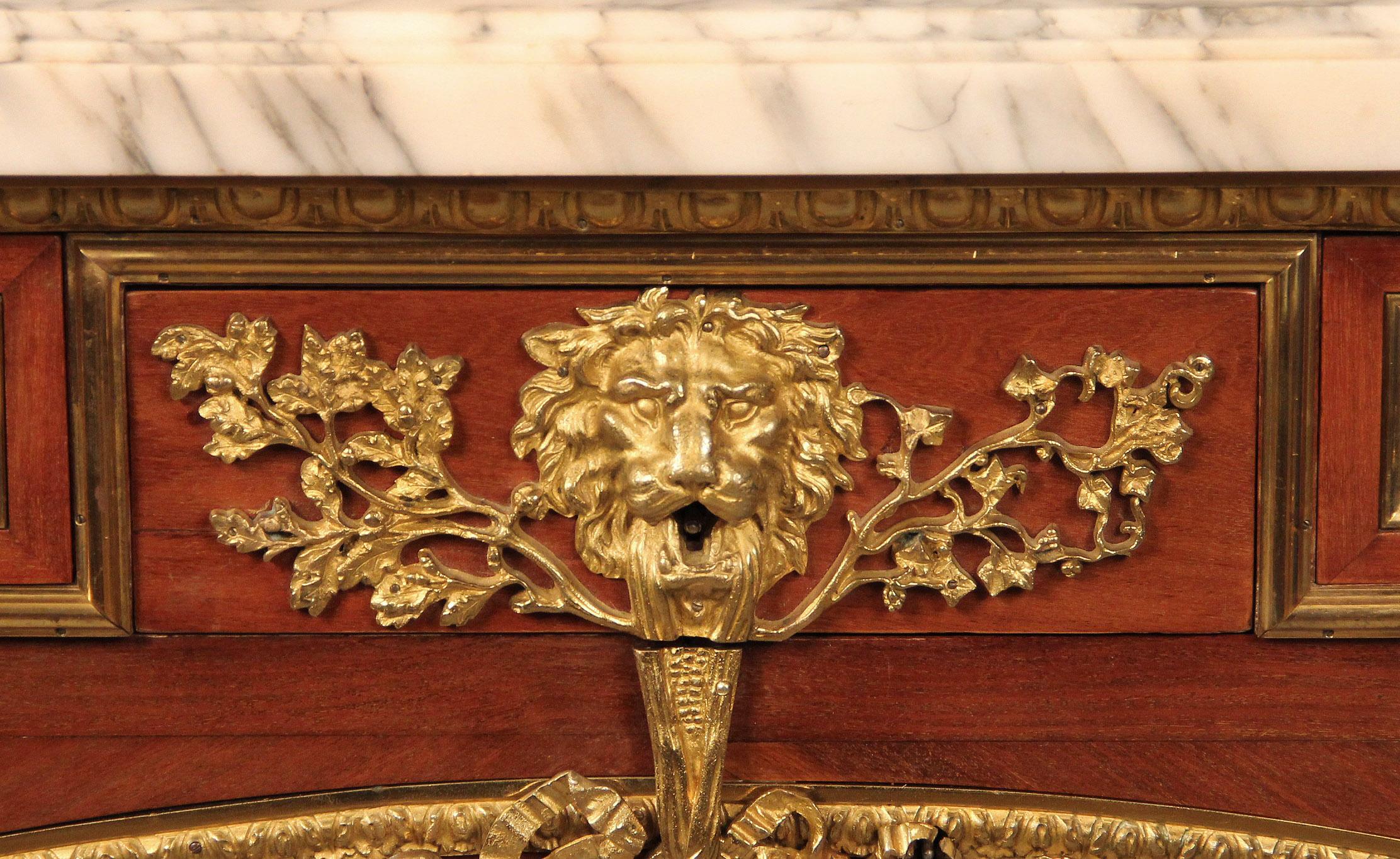 A nice quality late 19th century Louis XVI style gilt bronze mounted commode A Vantaux by Léon Kahn

Léon Kahn

A white marble top above a frieze applied with scrolling-vine mounts and fronted by three drawers centered by a lion’s mask and oak