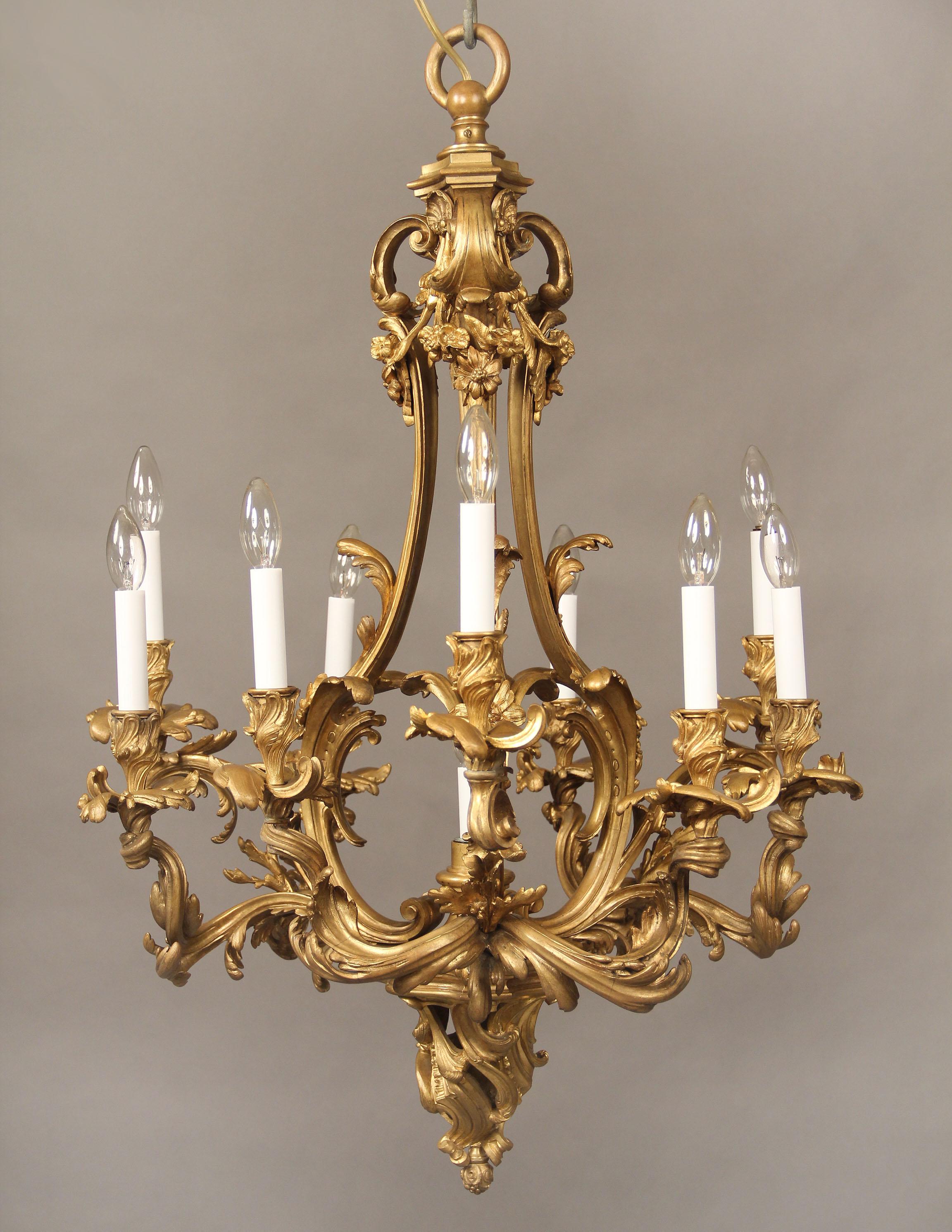 A nice quality late 19th century gilt bronze ten-light chandelier

Bronze casted frame with flowers and foliate spiraled arms. One center interior and nine-tiered perimeter lights.