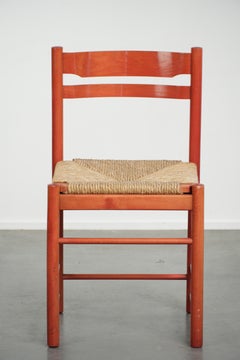Belle chaise vintage rouge en bois des années 1970 avec une assise en osier tressé.
