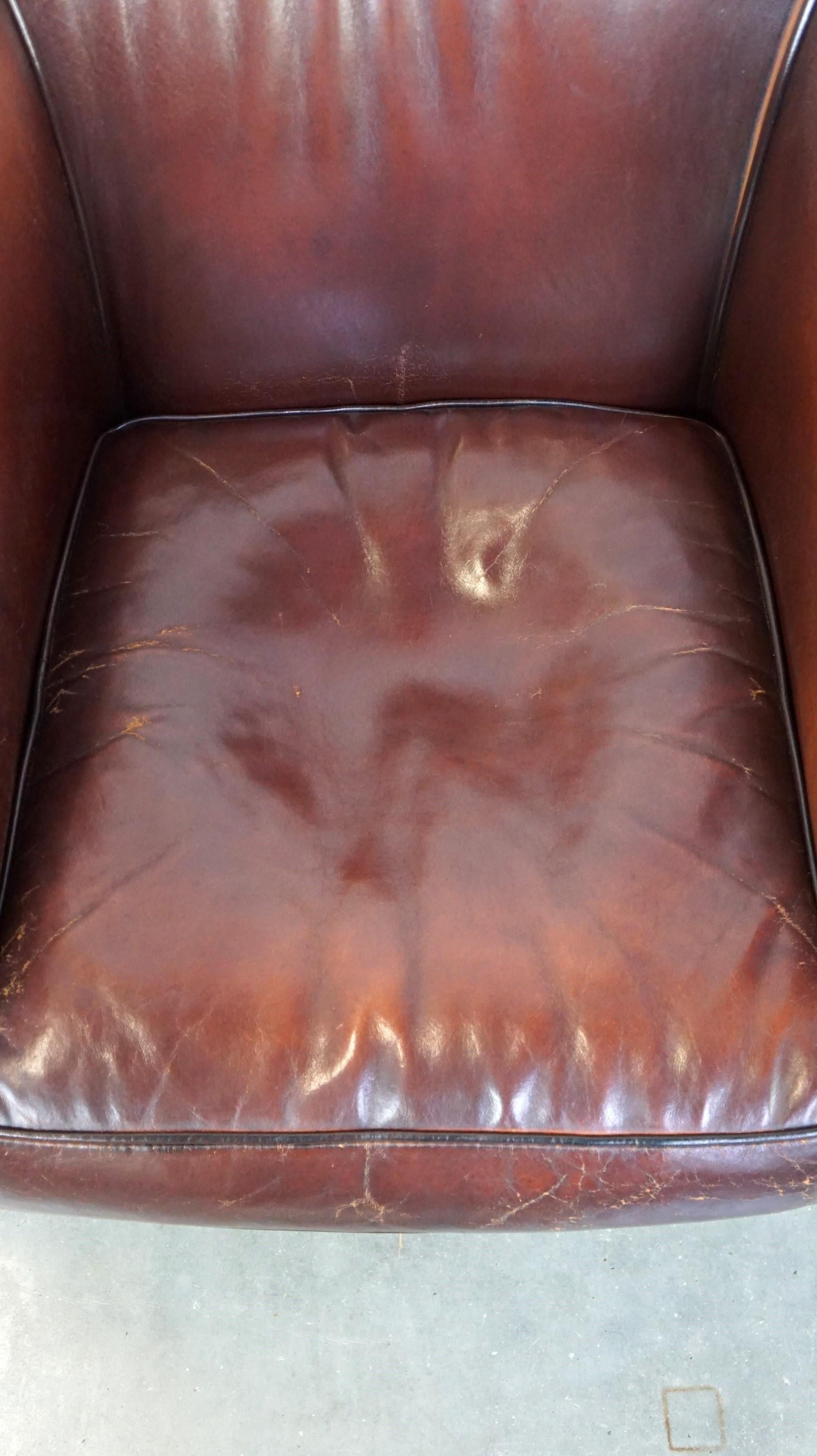 Leather Nice sheepskin club chair with a beautiful patina For Sale