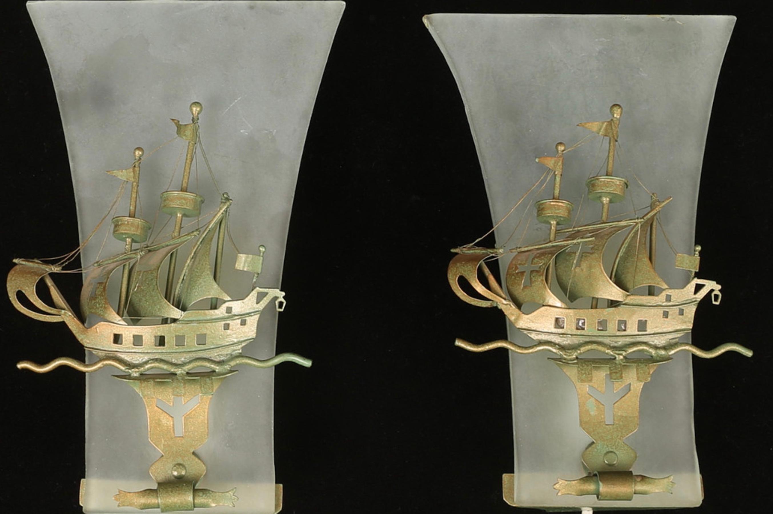 nice set of 2 wall sconces with sailing ships in front of sanded glass.