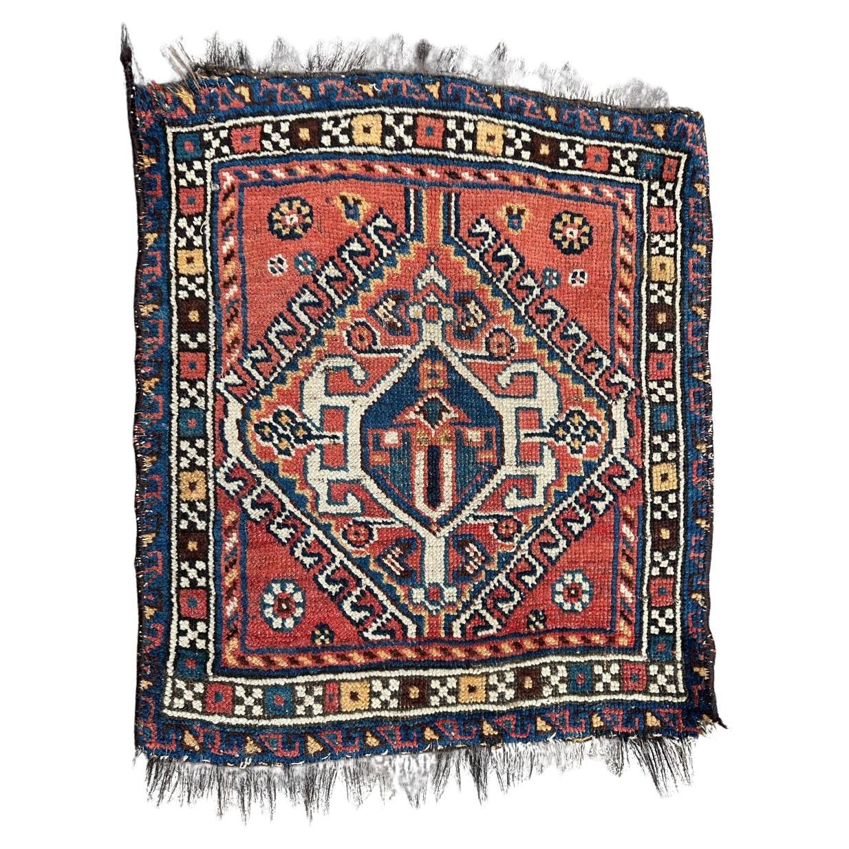 Beau tapis Qashqai ancien face à petit sac
