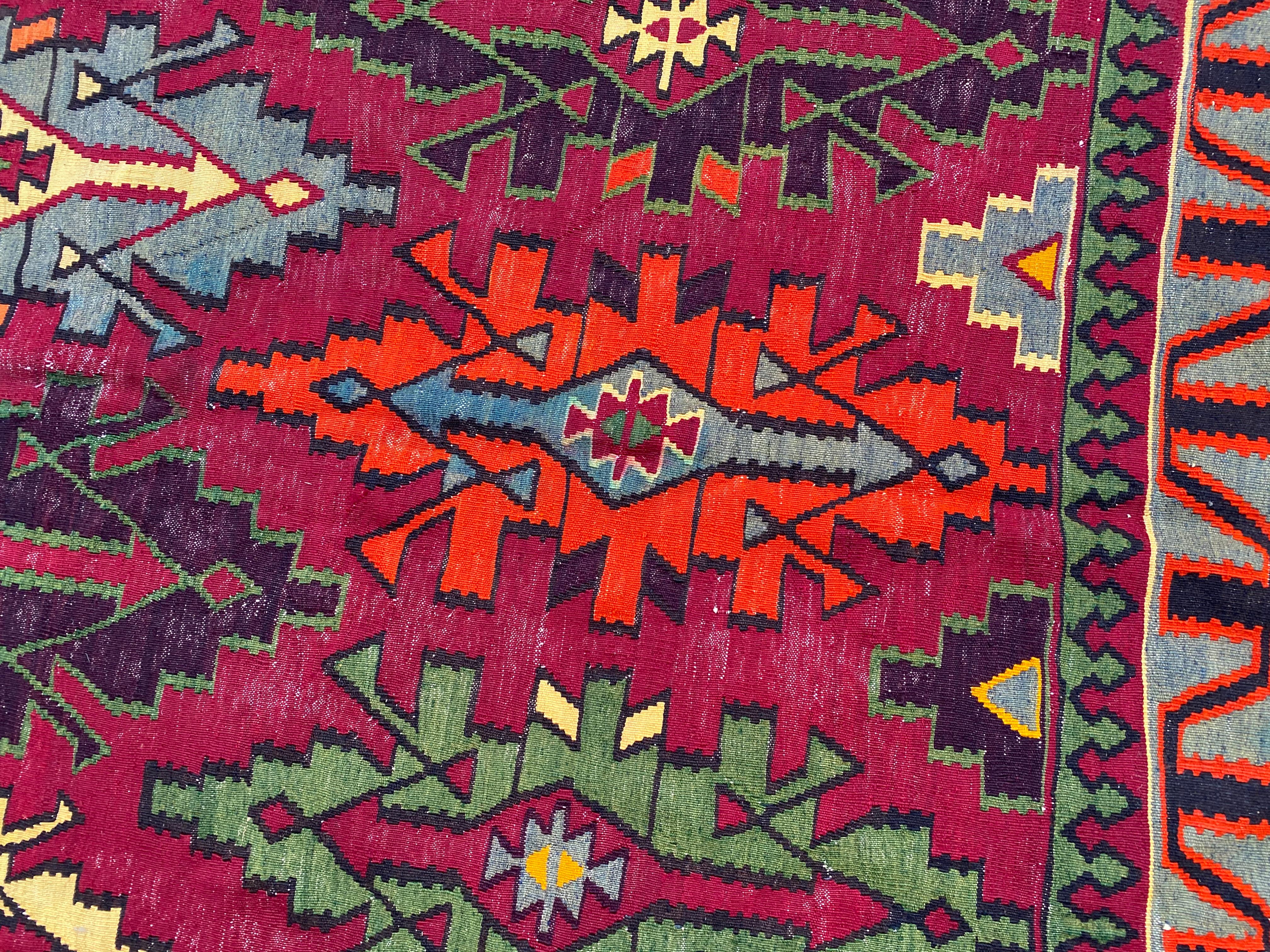 Discover the exquisite beauty of our Anatolian Kilim – a stunning masterpiece meticulously handwoven with wool on cotton. Adorned with a captivating geometrical design in vibrant colors such as purple, pink, blue, yellow, green, and orange, this