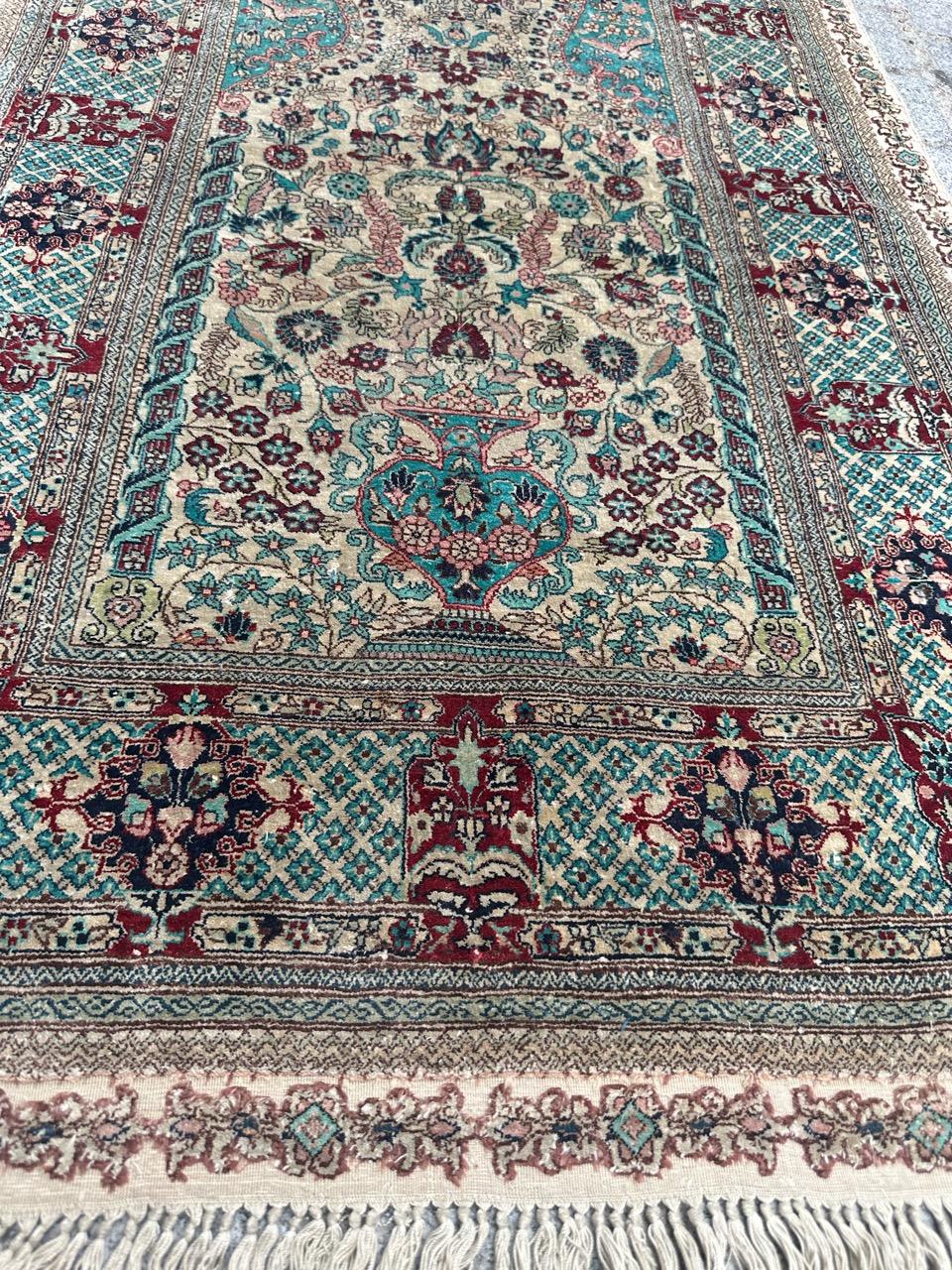 Introducing an exquisite late 20th-century silk rug that truly captivates with its intricate design. Adorned with splendid floral motifs within a mesmerizing mihrab, this piece boasts an array of enchanting colors, notably a stunning green and beige
