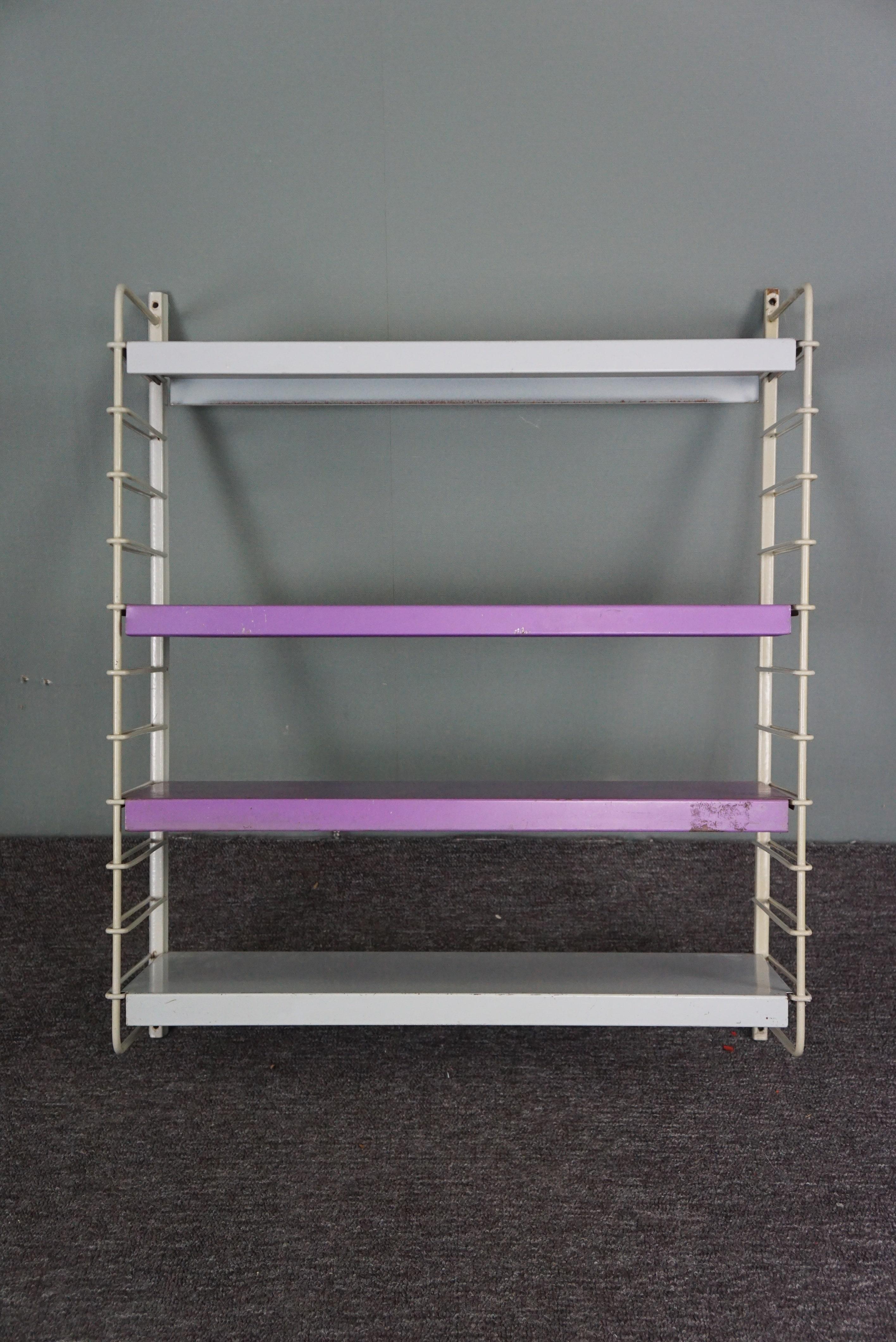 Offered is this Modernist style icon in purple and gray.

This wall rack/wall unit consists of two wall parts and four shelves which can be placed at your own discretion so that you can change/supplement the layout of this wall rack at your own