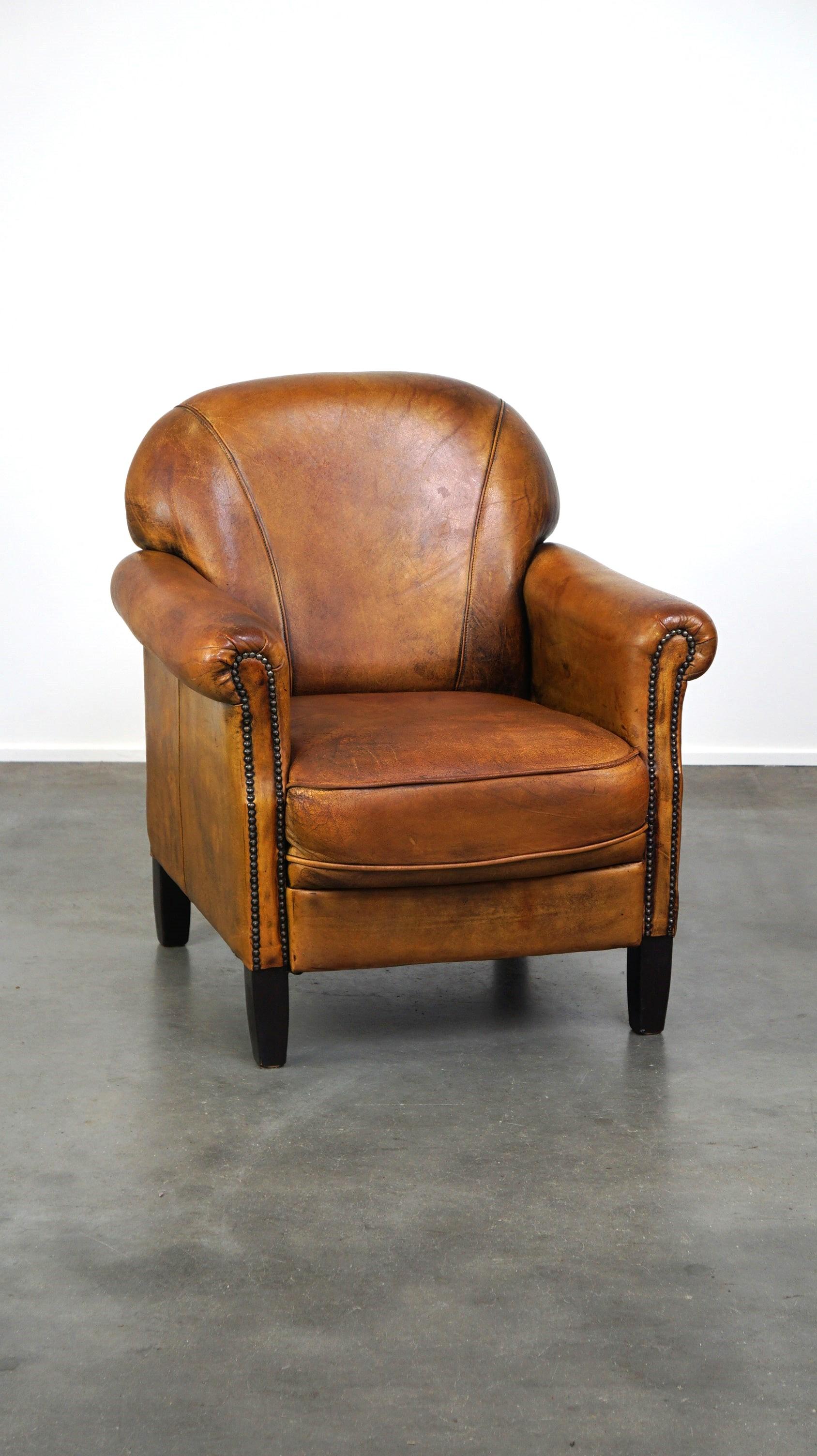 Offered this nice vintage sheep leather armchair with beautiful colors and a comfortable seat.

This sheep leather armchair has acquired a great patina over the years. Due to its size and design it can easily be placed in almost any interior style
