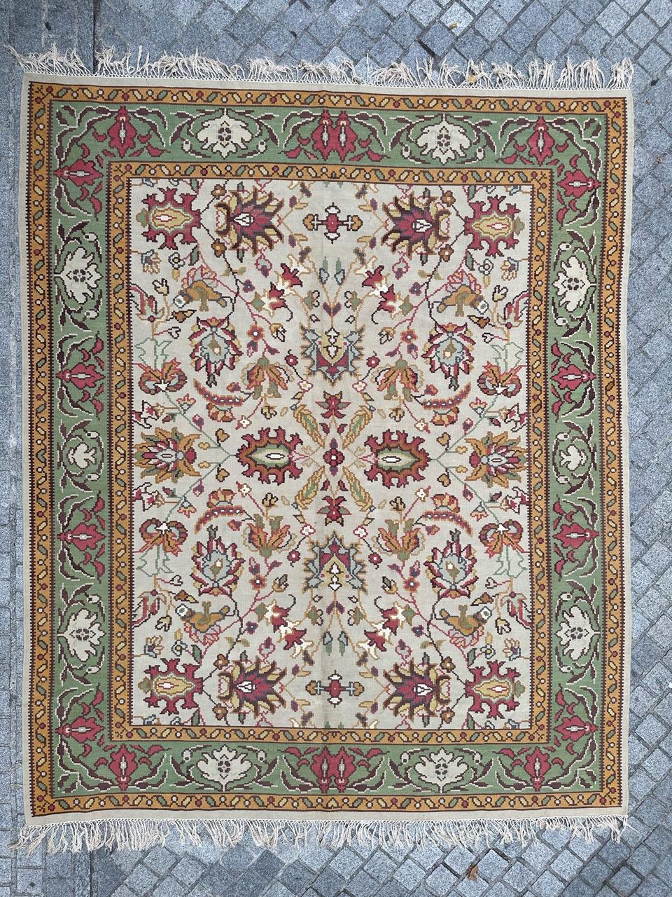 Schöner Vintage-Kilim mit einem atemberaubenden, von antiken Oushak-Teppichen inspirierten Design in hellen Farben. Dieses exquisite Stück ist vollständig handgewebt und besteht aus Wollsamt auf einem Baumwollgrund. Vor einem weichen beigen