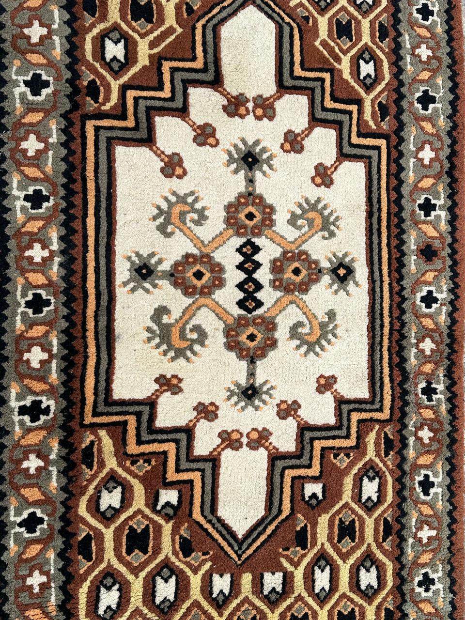 Grazioso tappeto tribale di metà secolo proveniente dalla Tunisia con un bel disegno geometrico e bei colori con un médaillon rosso e campo bianco e con 
grigio, arancione, nero e bianco. Interamente annodato a mano con lana su una base di cotone