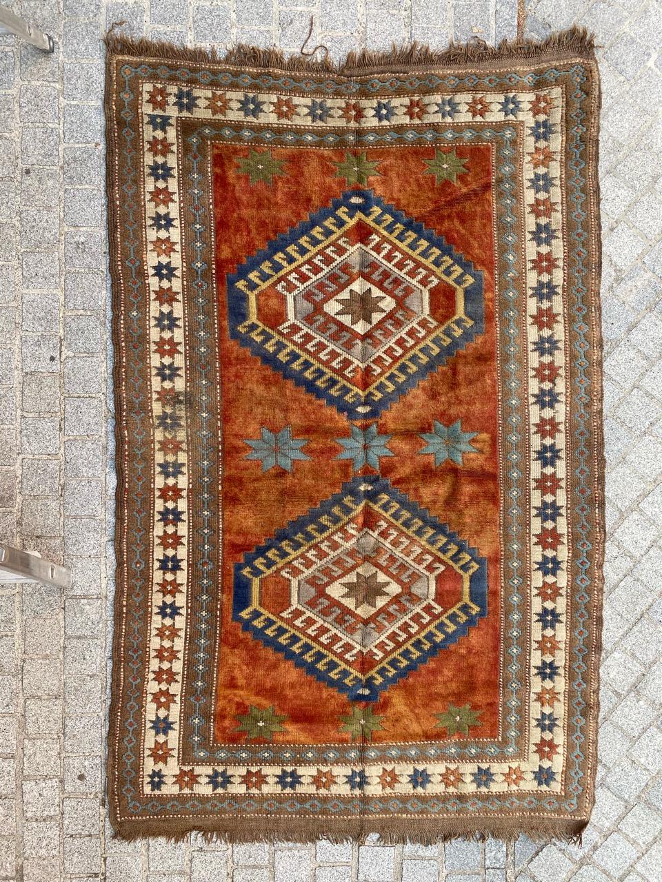 Exquisite vintage Turkish rug from the Kars region, dating back to the mid-20th century. This handmade masterpiece features intricate hand-knotted craftsmanship in wool on wool, showcasing a design reminiscent of antique Caucasian Kazak rugs. The