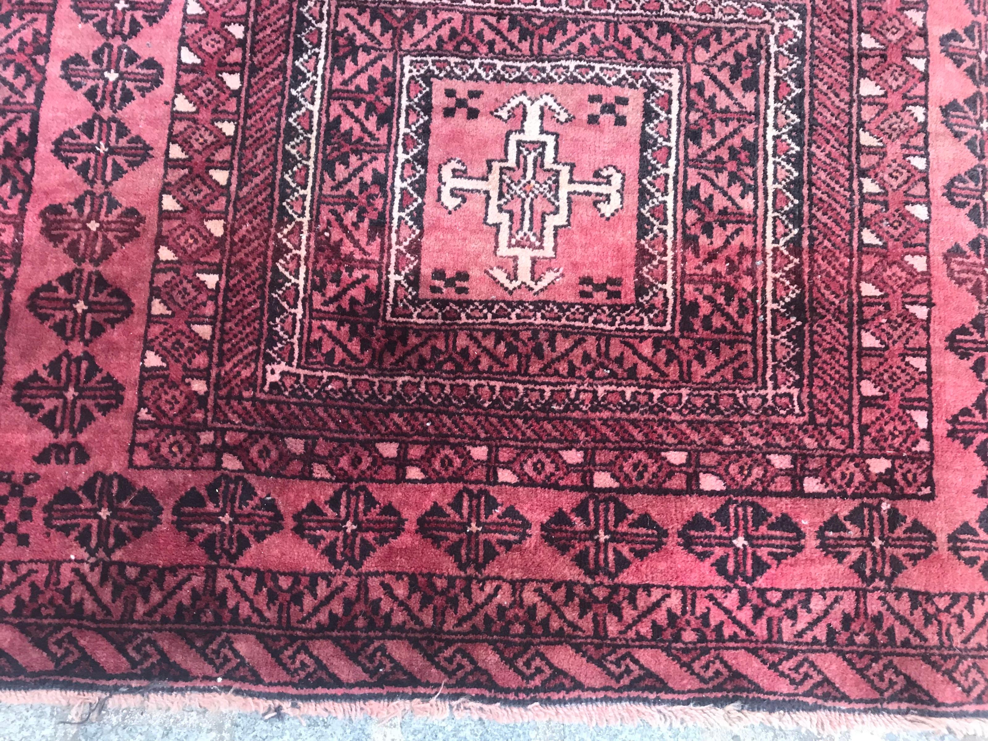 Magnifique tapis afghan Baluch de la fin du 20ème siècle avec un design géométrique tribal et un champ de couleur marron et rose, entièrement noué à la main avec du velours de laine sur une base de coton.