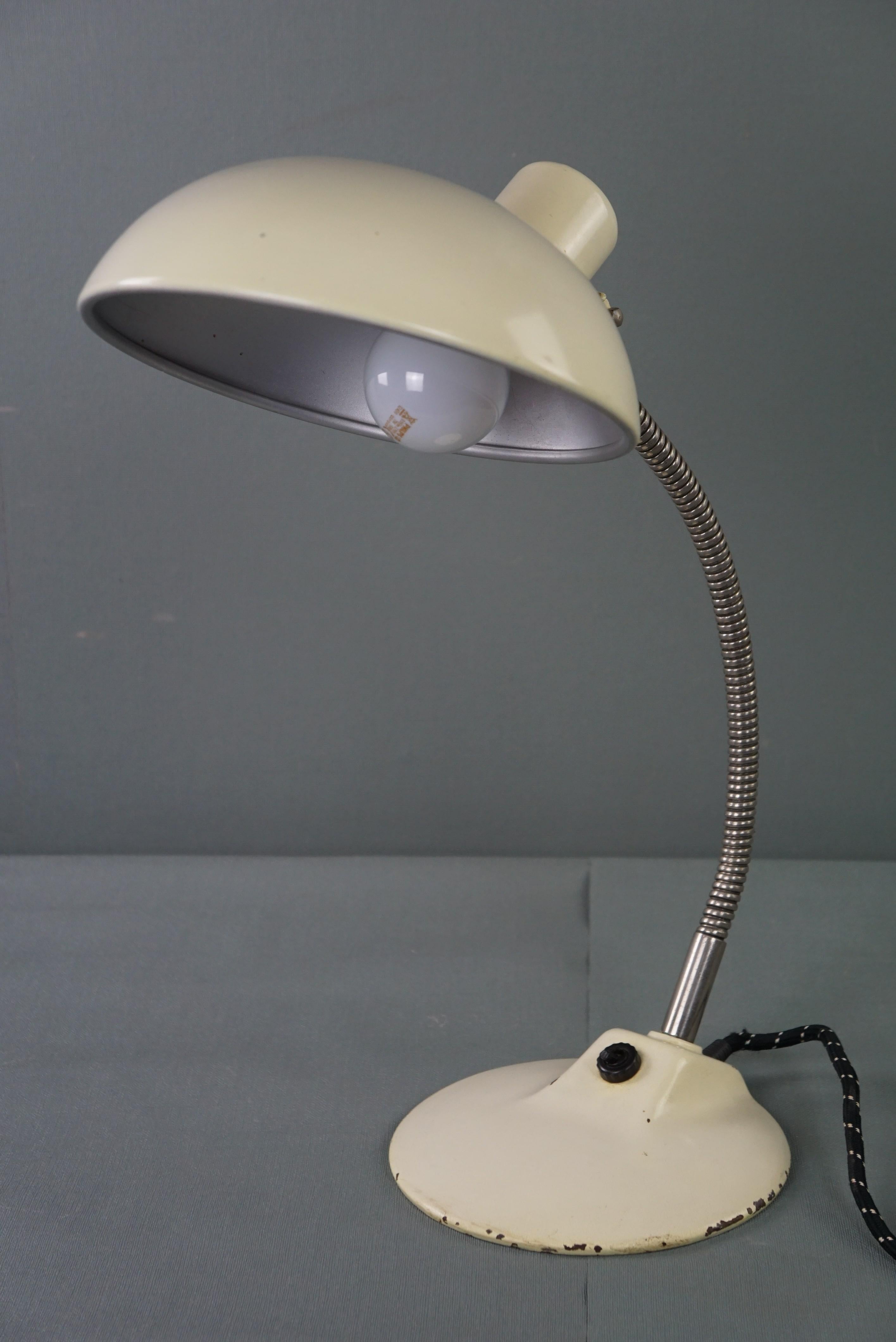 Offered is this very nice white vintage metal lamp/desk lamp in Bauhaus style from the 1960s.

This beautiful vintage 1960s lamp looks great on your desk, but also on your nightstand, dresser, or table. This lamp has a bendable neck, and you switch