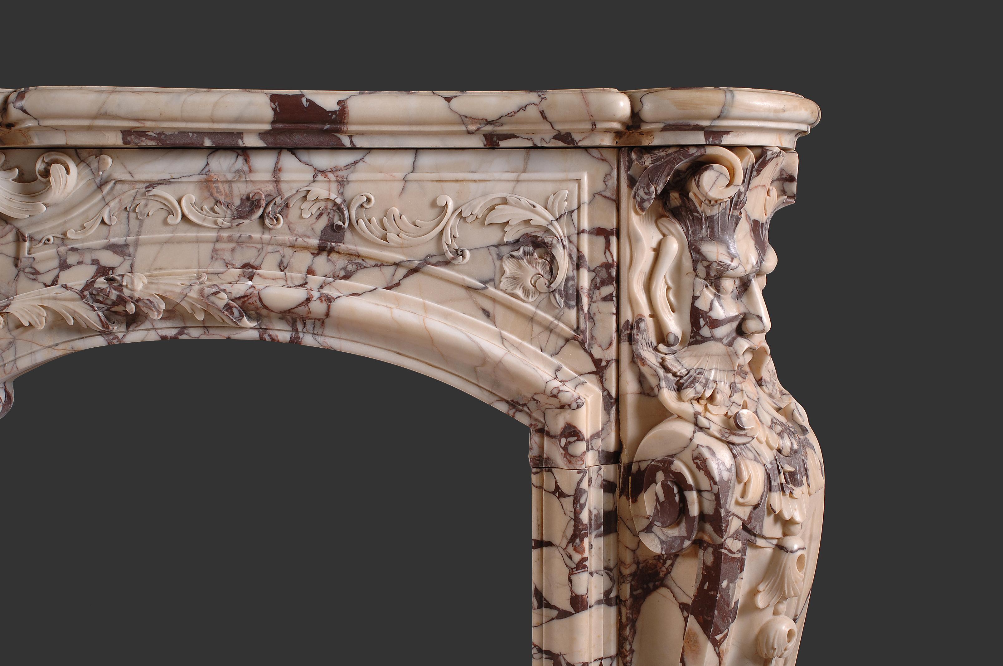 Beautiful Louis XV fireplace model in « Rosso White » marble
The serpentine shelf sits over a shaped frieze which is centered by a extremely fine carved central double shell cartouche. 
The lintel end blocks depicting carved devil mask with oak leaf