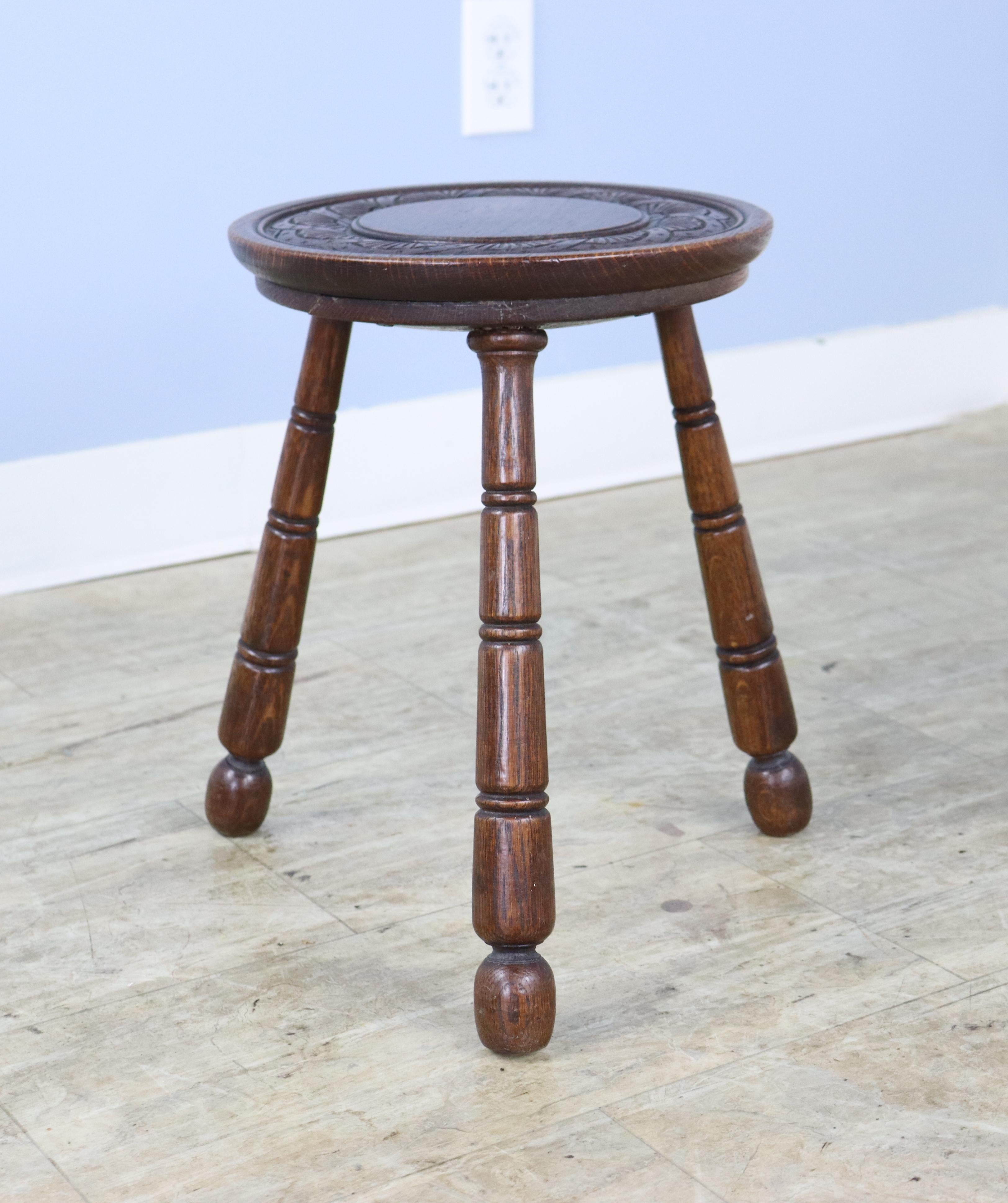 A sweet foot stool with a attractively carved seat. Tripod base in the style of a milking stool, and perfect as a comfortable seat by the fire, a perch for one's drink, or as a seat for a child.   The diameter measurement is for the entire stool. 