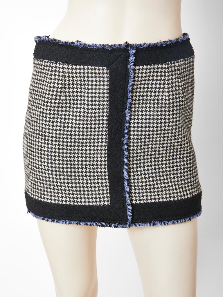 Nicholas Ghesquiere for Balenciaga, black and white, wool houndstooth  sleeveless suit, having a mini skirt, and a high neck jacket with patch pockets below the bust. Suit has black wool panels  along the skirt hem, center front and shoulders. An